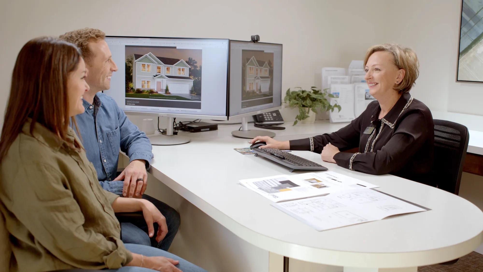 Couple finalizing custom home selections with design consultant at Drees