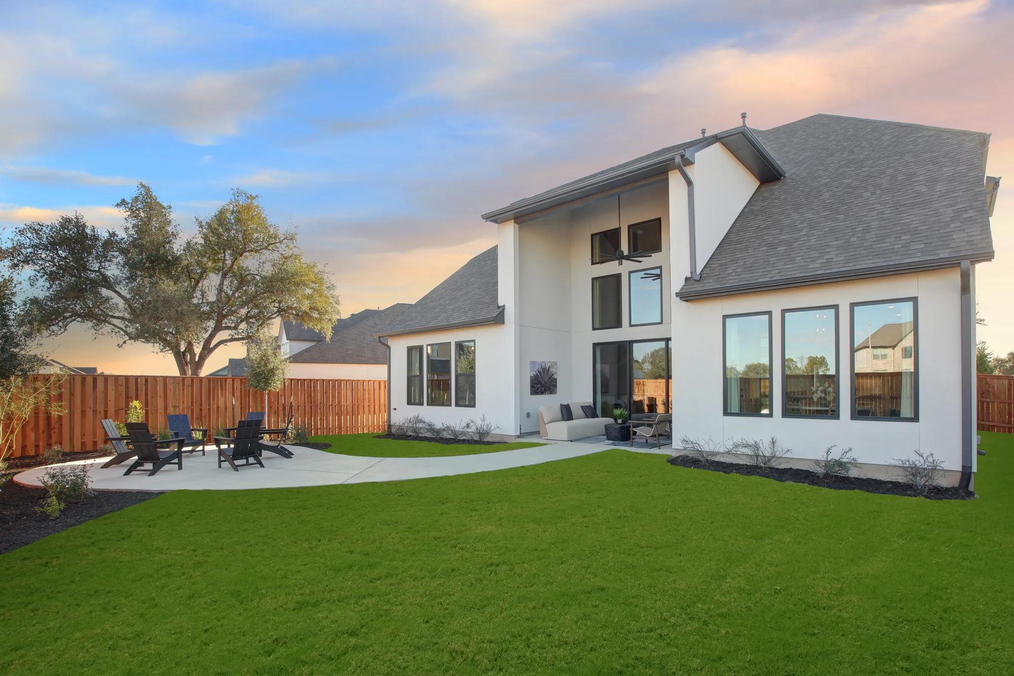 Custom home fenced in backyard with covered patio and concrete extension