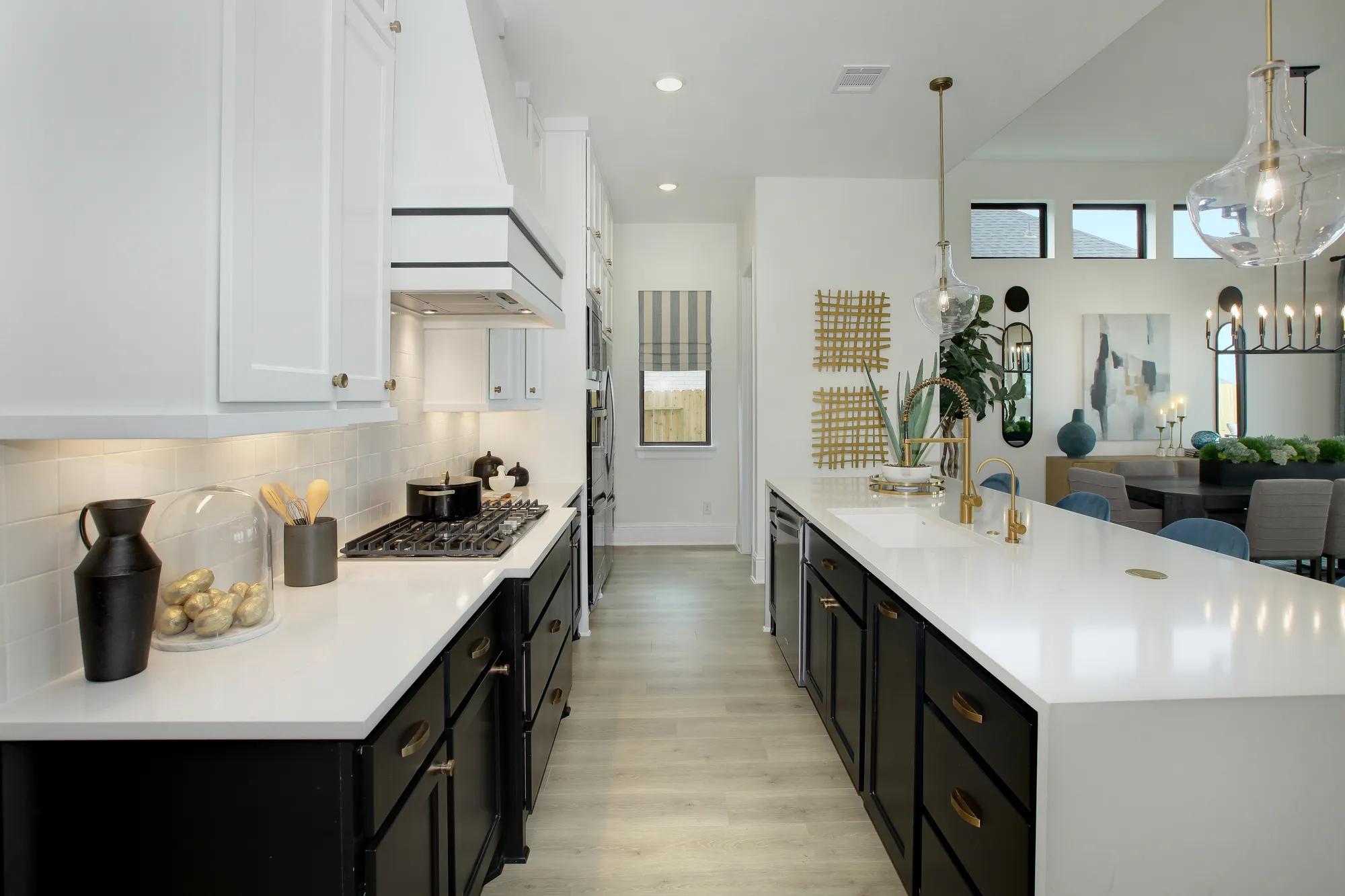 Custom home kitchen with black lower cabinets and white upper cabinets with white countertops 
