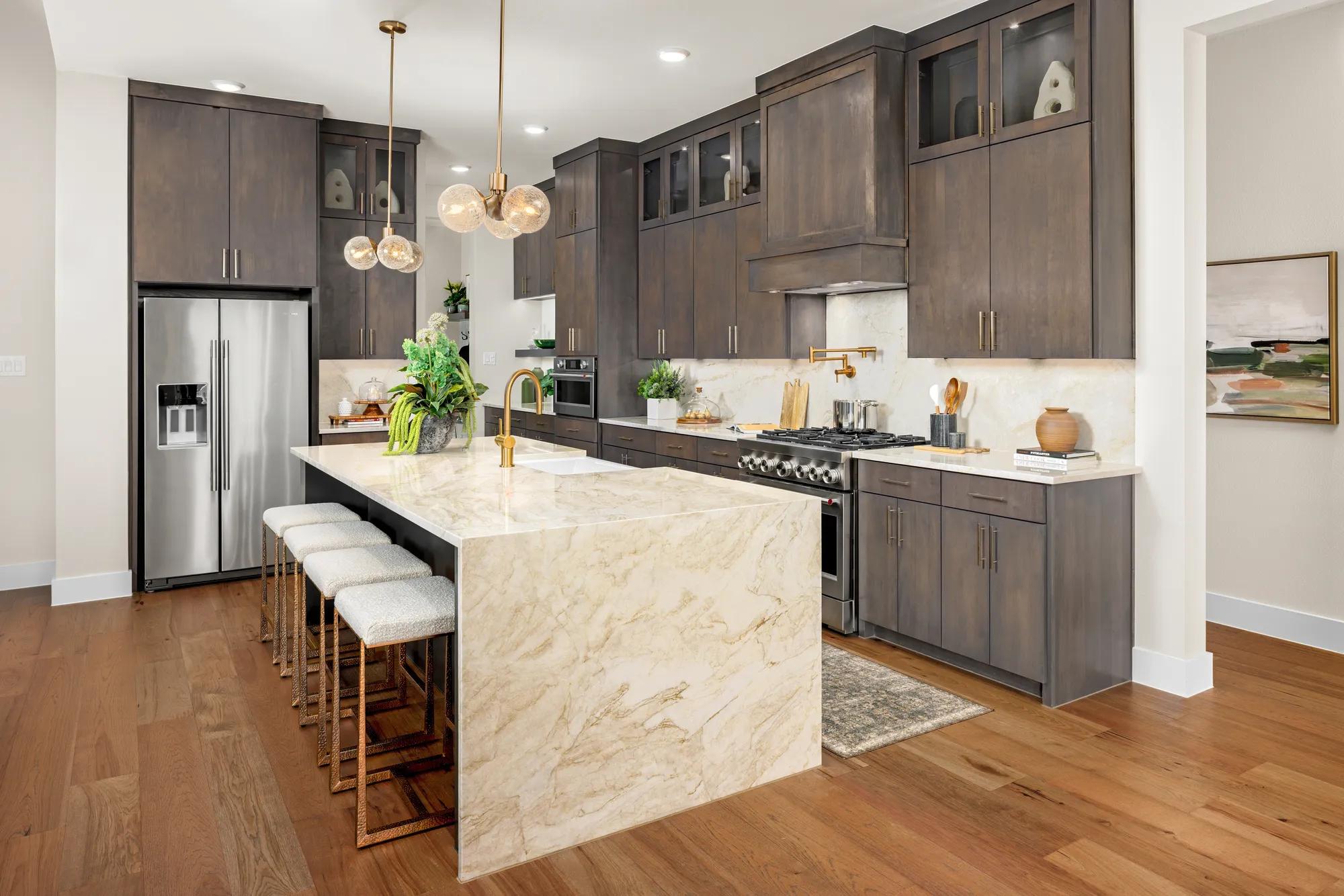 New home kitchen with dark wood cabinets and creamy waterfall island