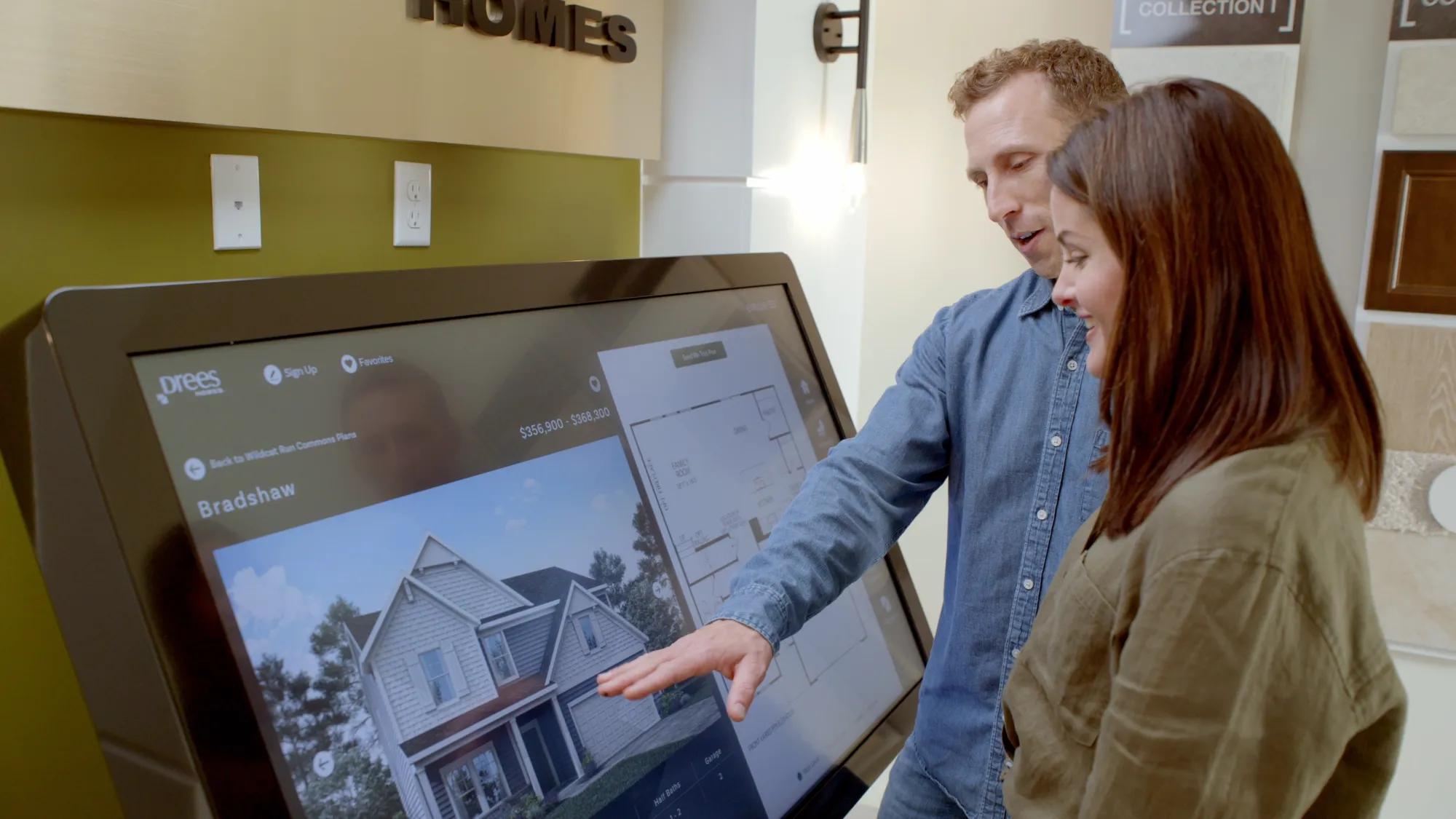 Couple using kiosk at Drees model home