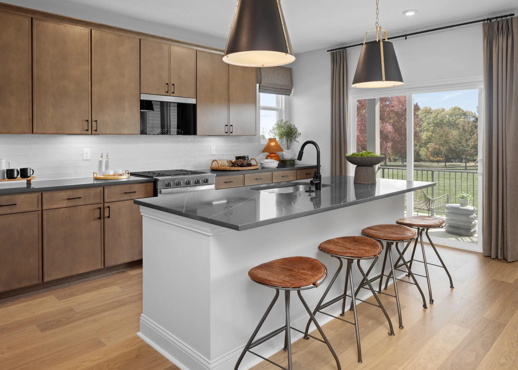 custom home island with stools and light wood cabinets