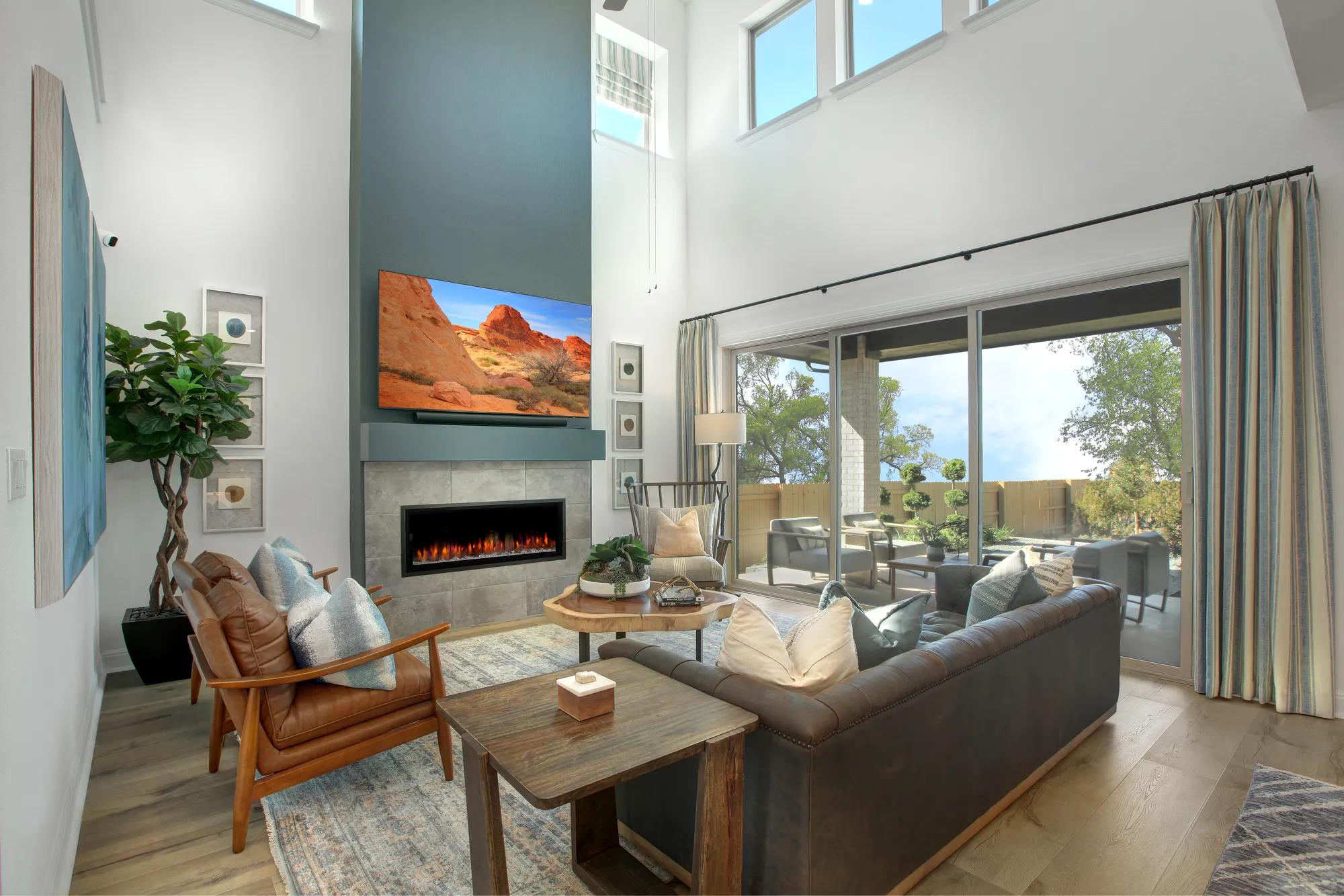 Custom home two-story family room with blue fireplace and sliding glass doors to back patio