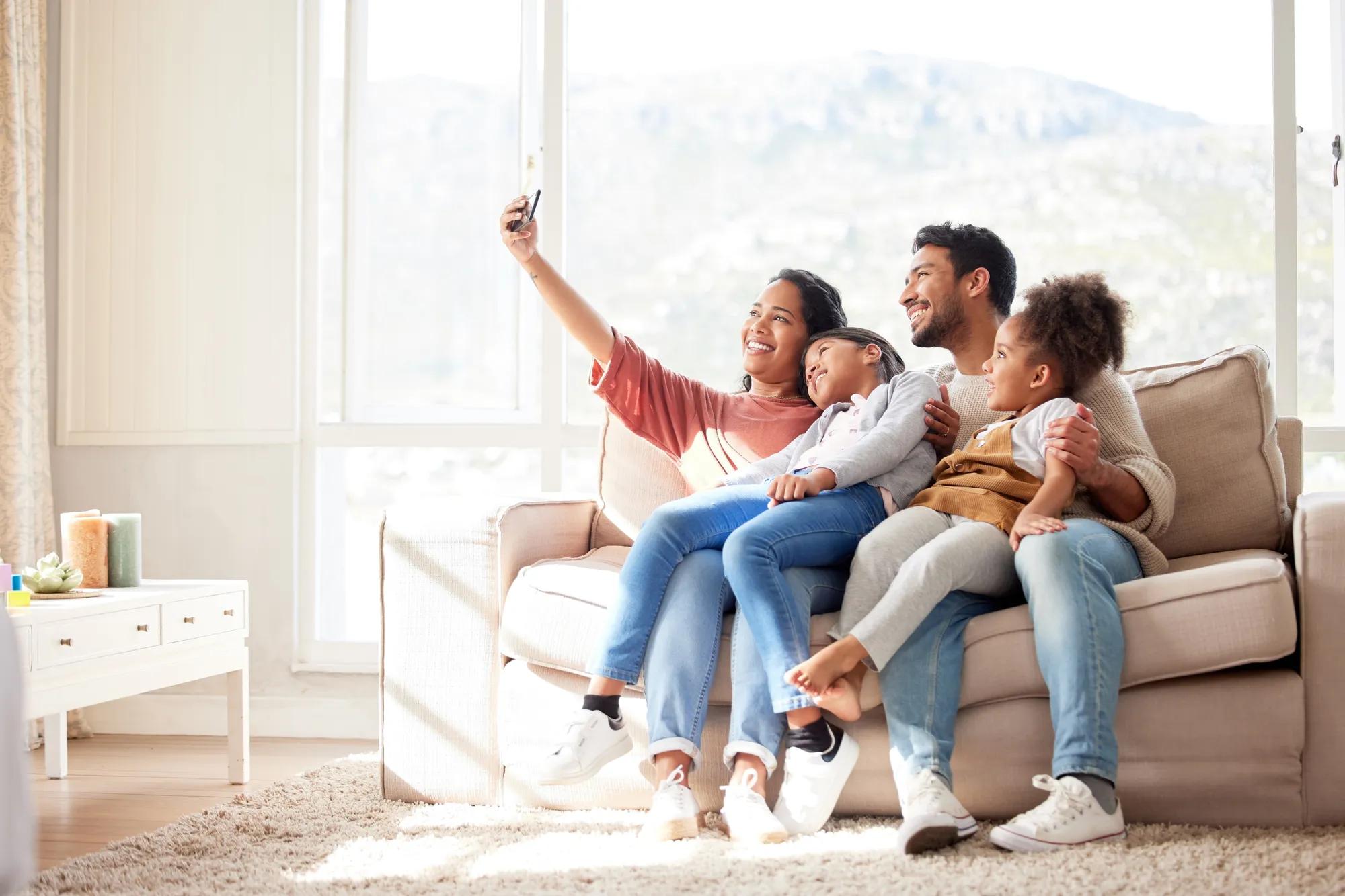 Family taking photo together on couch in new home living room