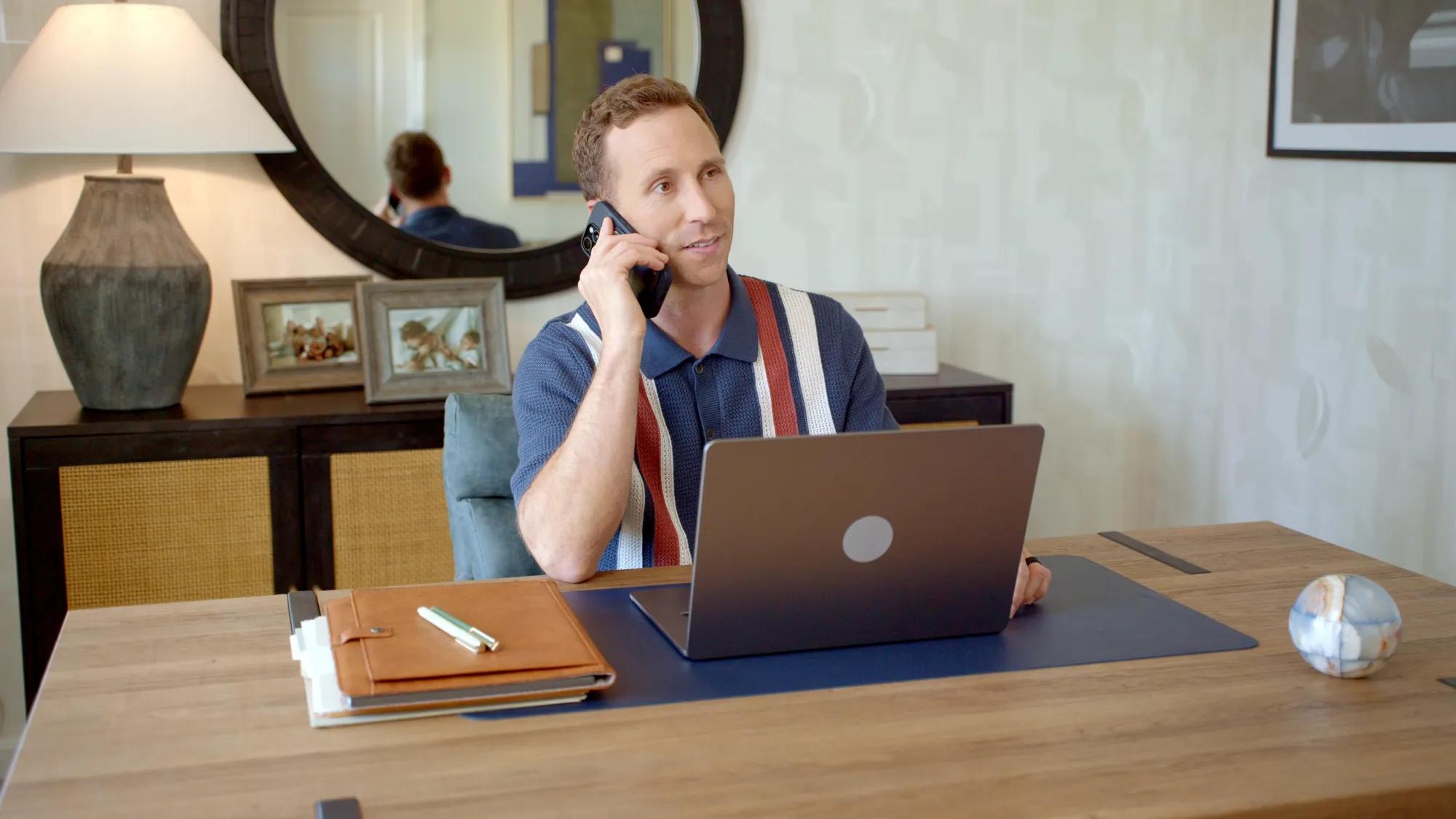 Man on phone and laptop in home office