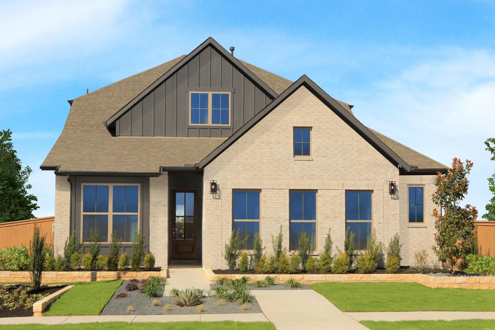 Two-story custom home with light brick, brown board and batten, and tan trim