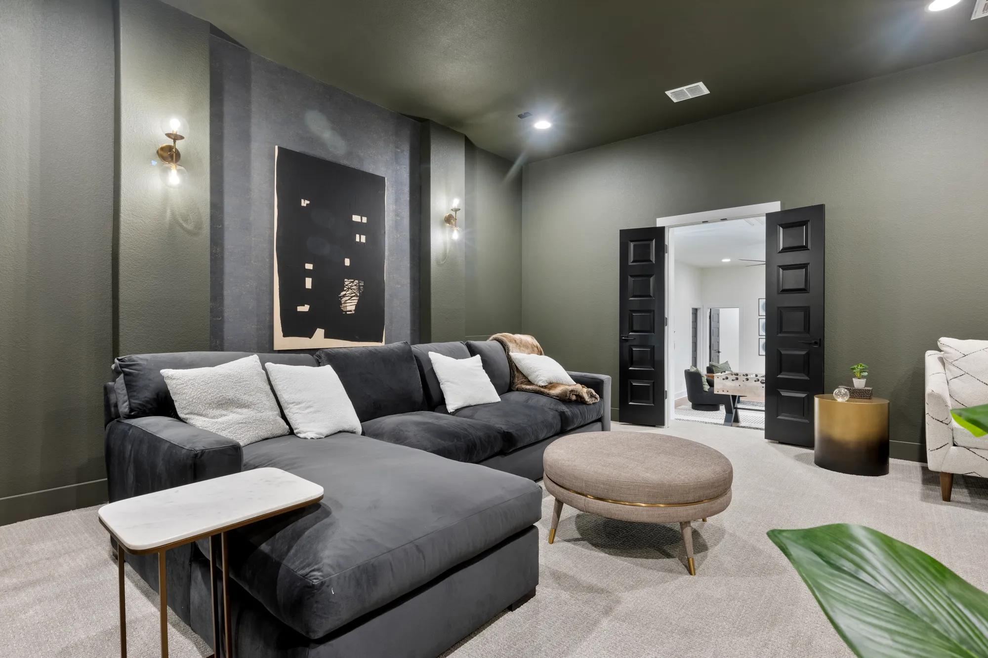 Custom home media room with green color drenched walls and ceiling
