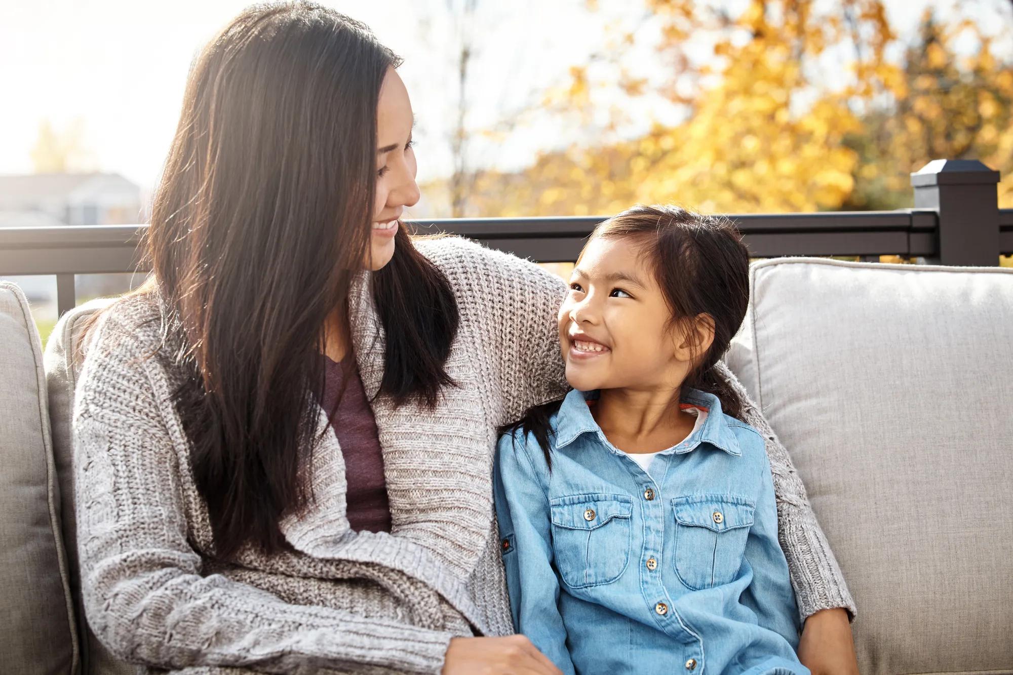 Mother and daughter relaxing outside of home