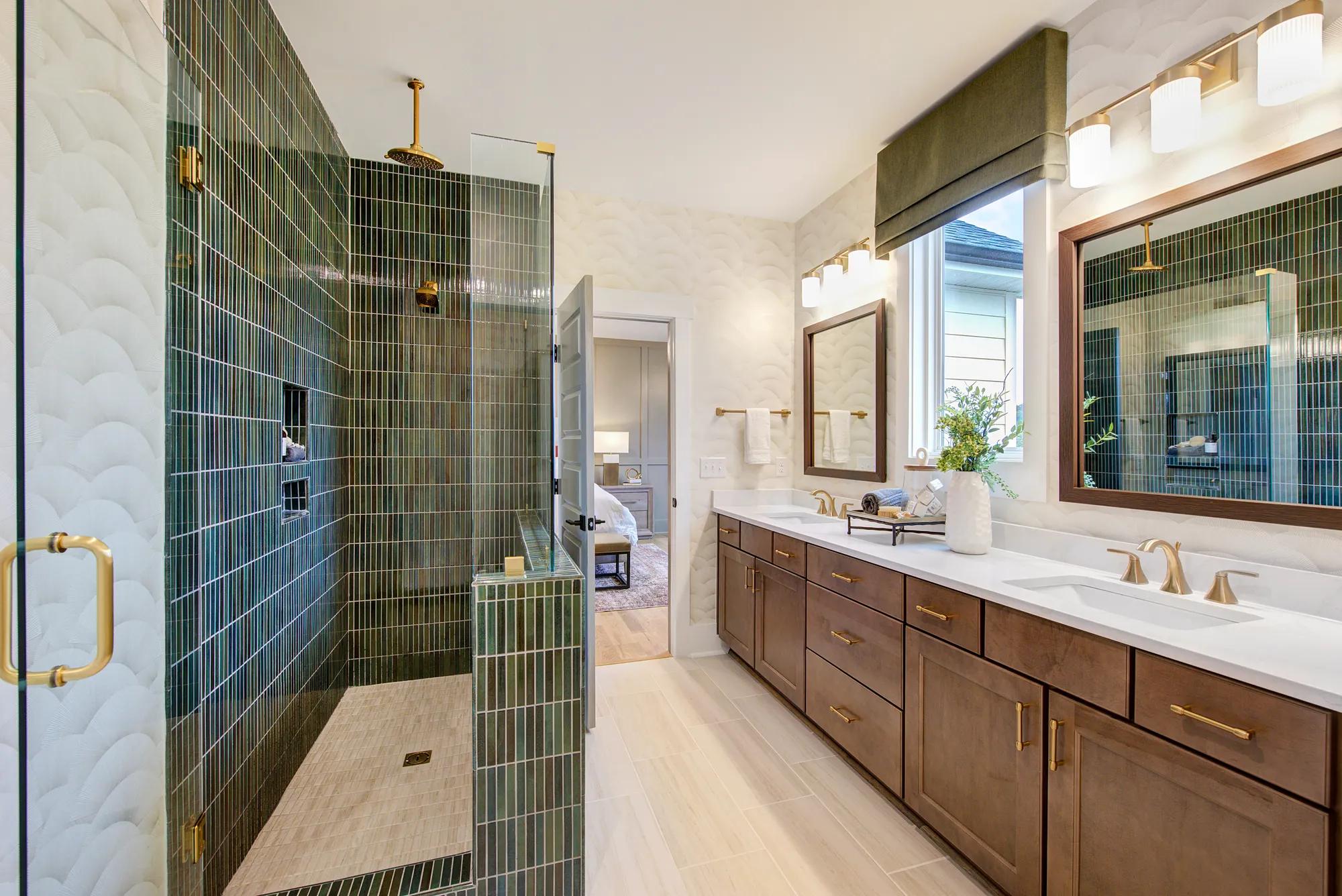 New home primary bath with decorative shower tile, luxury vinyl tile flooring, and dark wood cabinets