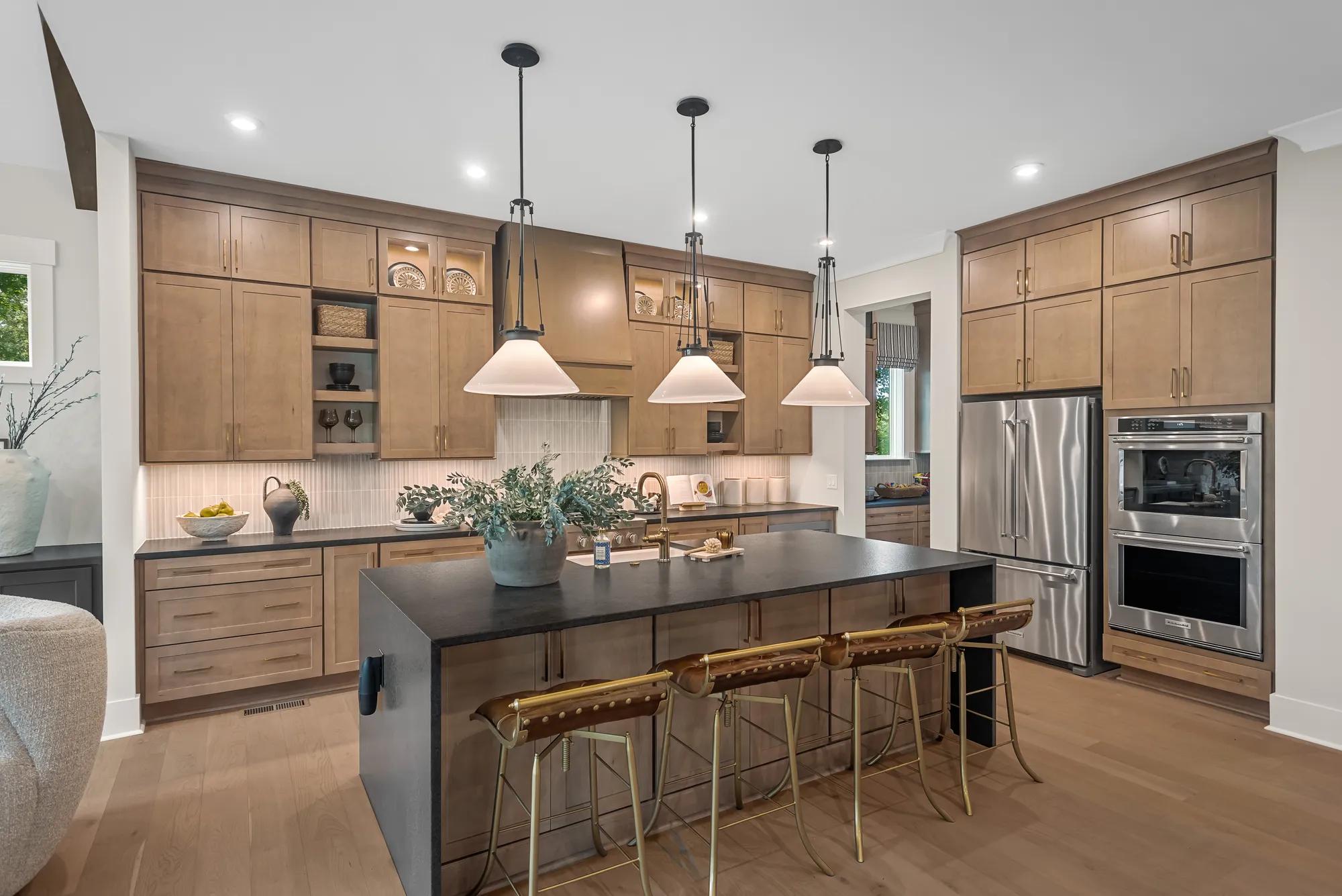 Custom home kitchen with light wood cabinets and stainless steel double ovens