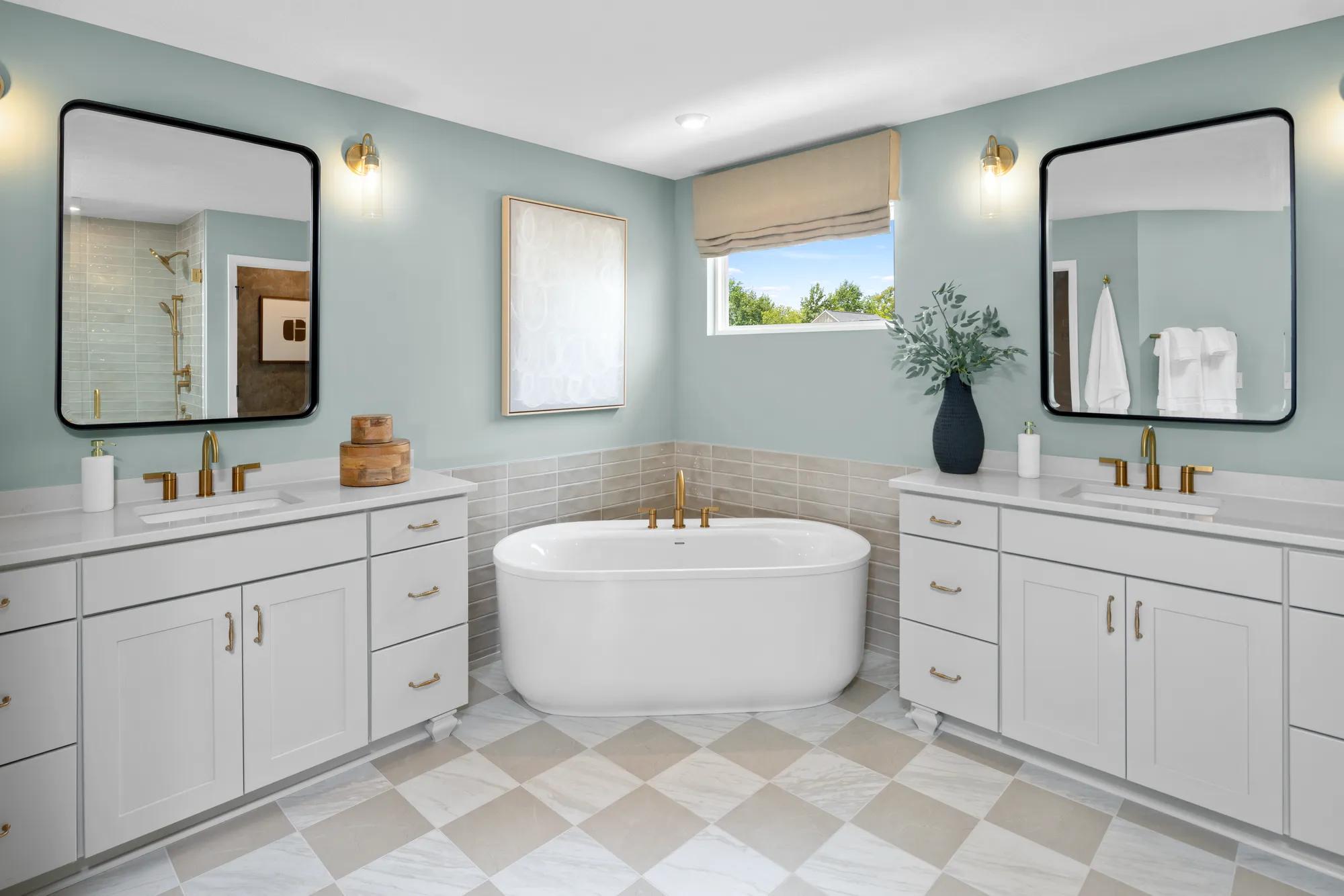 Custom home light and airy primary bathroom with dual vanities, freestanding tub, and checkered tile flooring