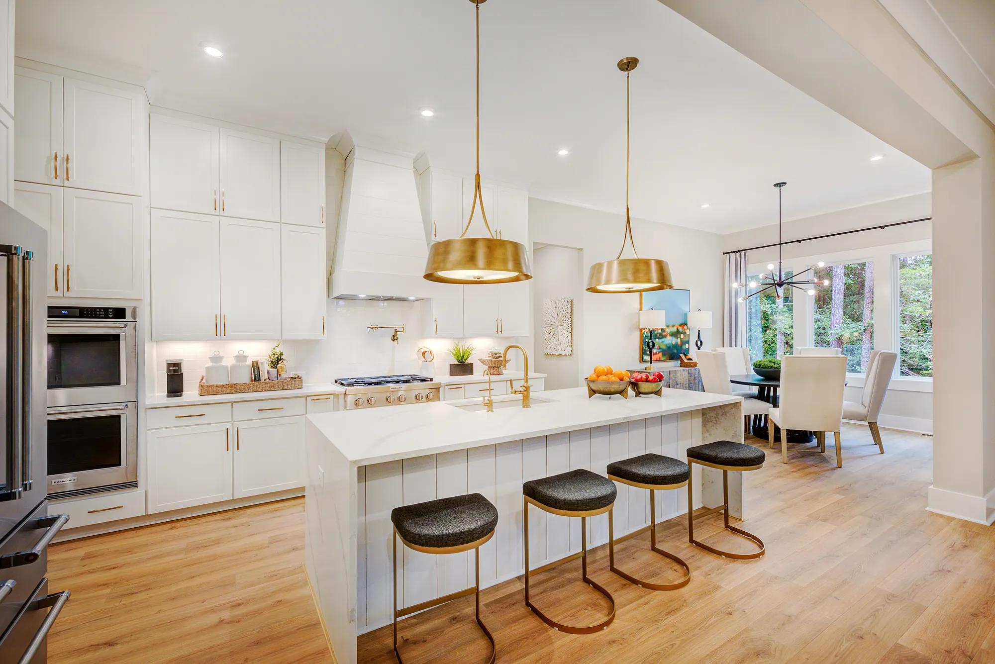 Custom home kitchen with white cabinets and countertops and waterfall island