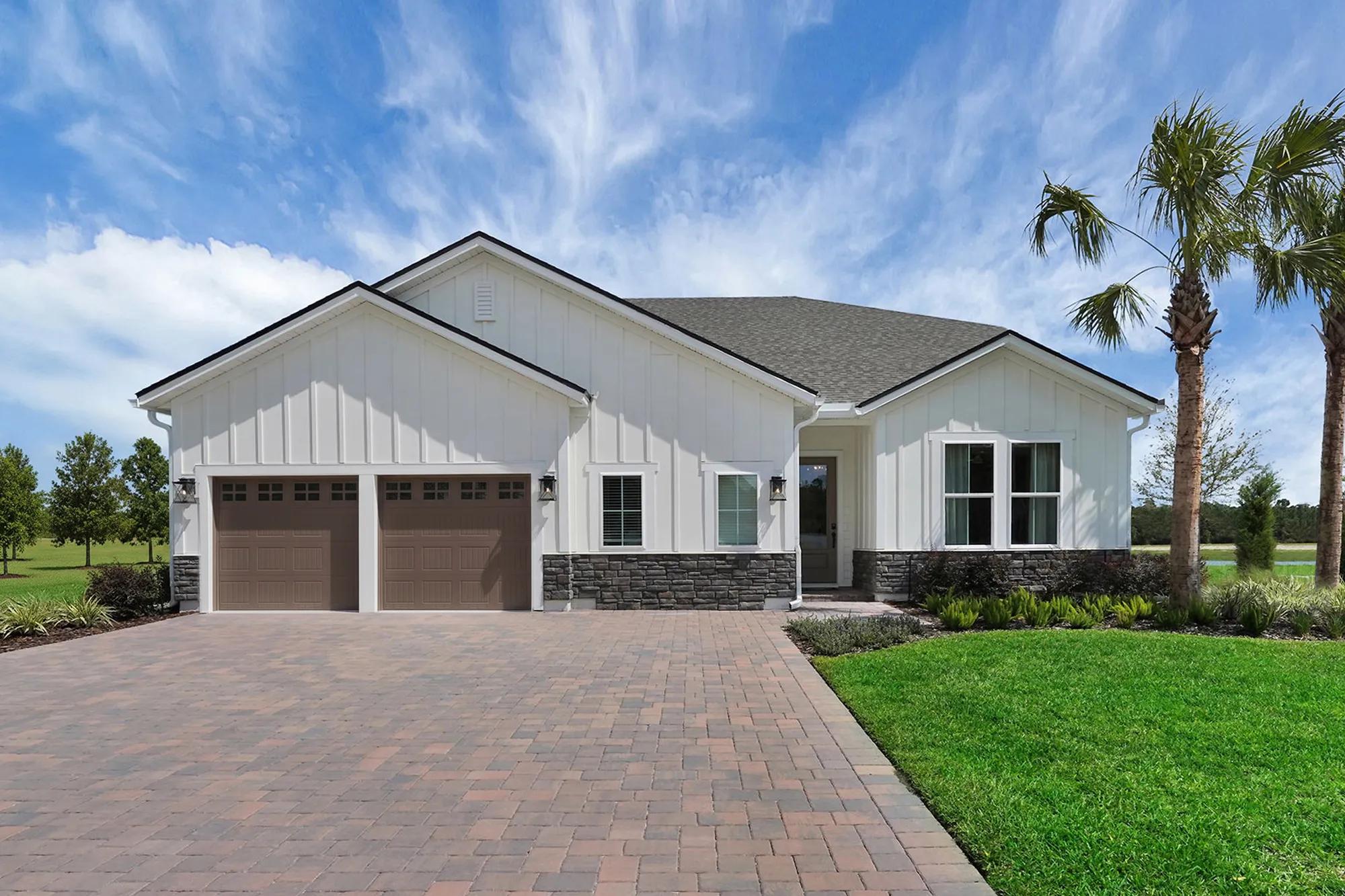 White custom home with pavestone driveway and palm tree landscaping