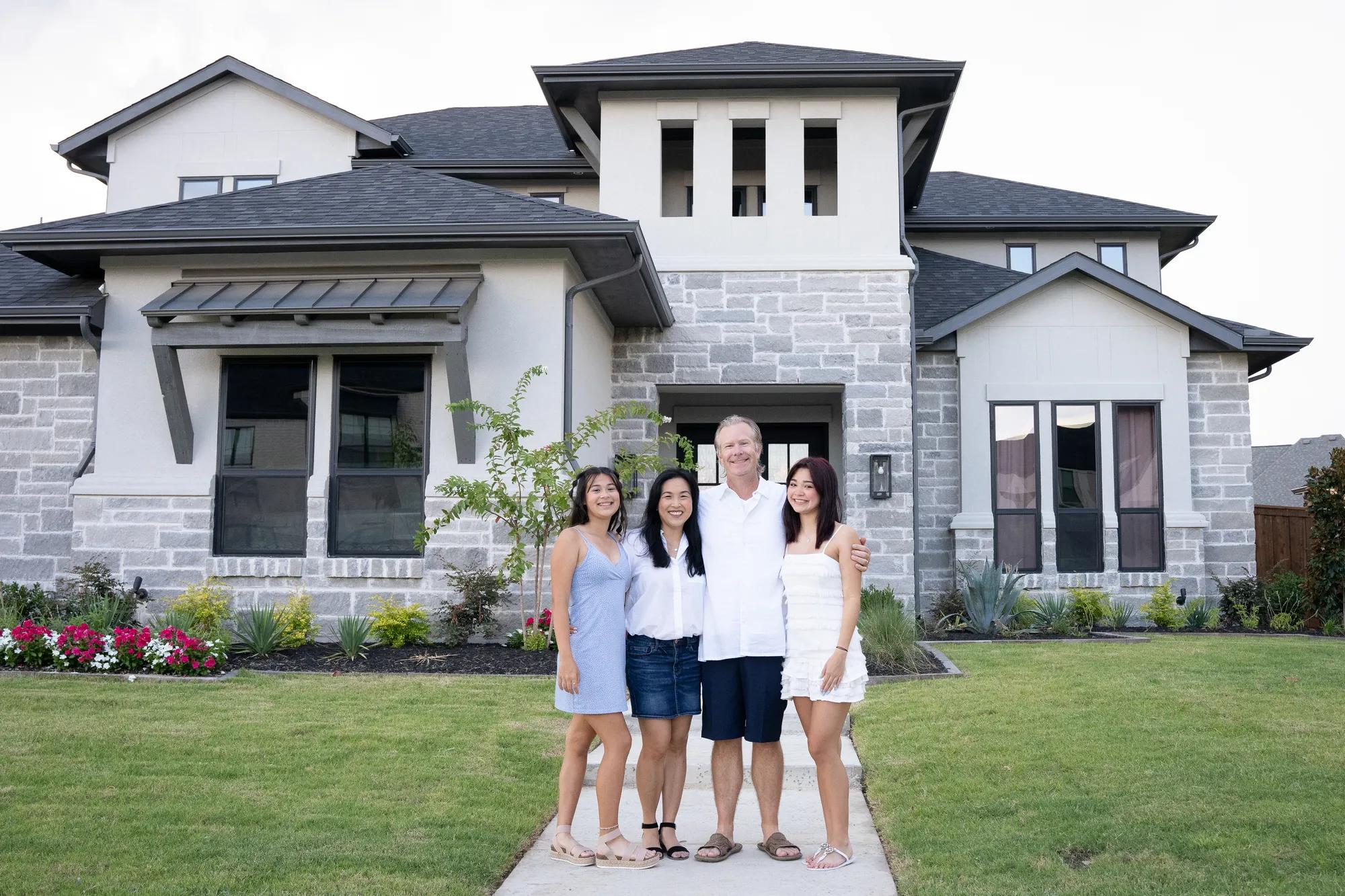 New homeowners enjoying the beautiful front yard of their gorgeous Lynmar style home