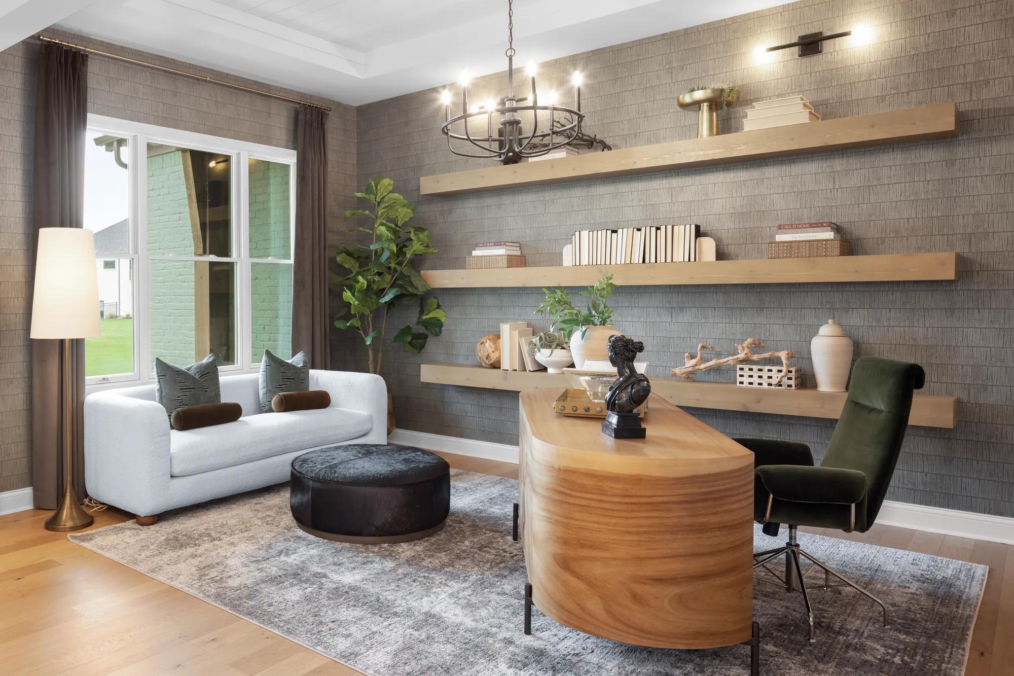 Custom home office with light wood long floating shelves and wallpaper