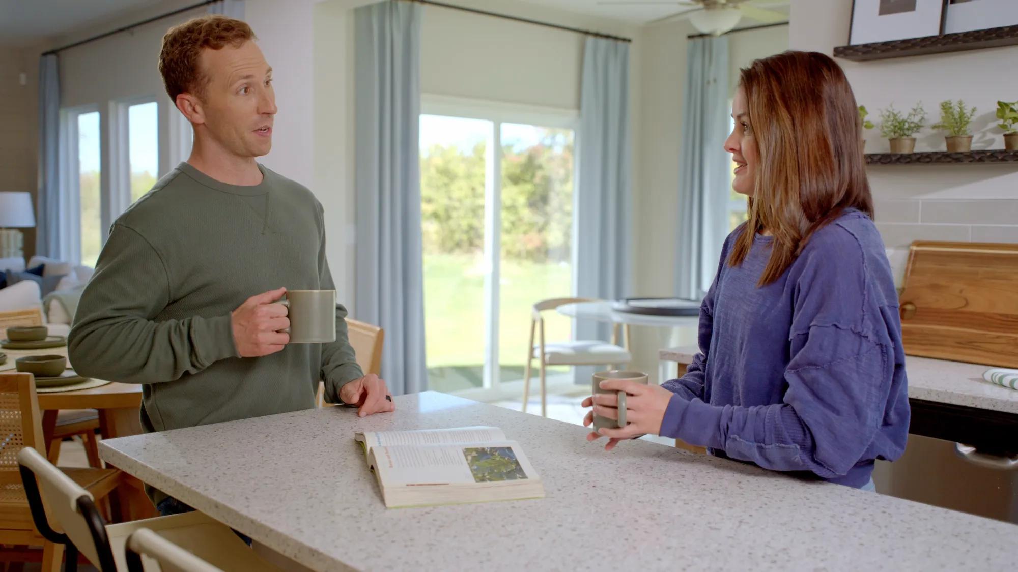 Couple talking at kitchen island over coffee