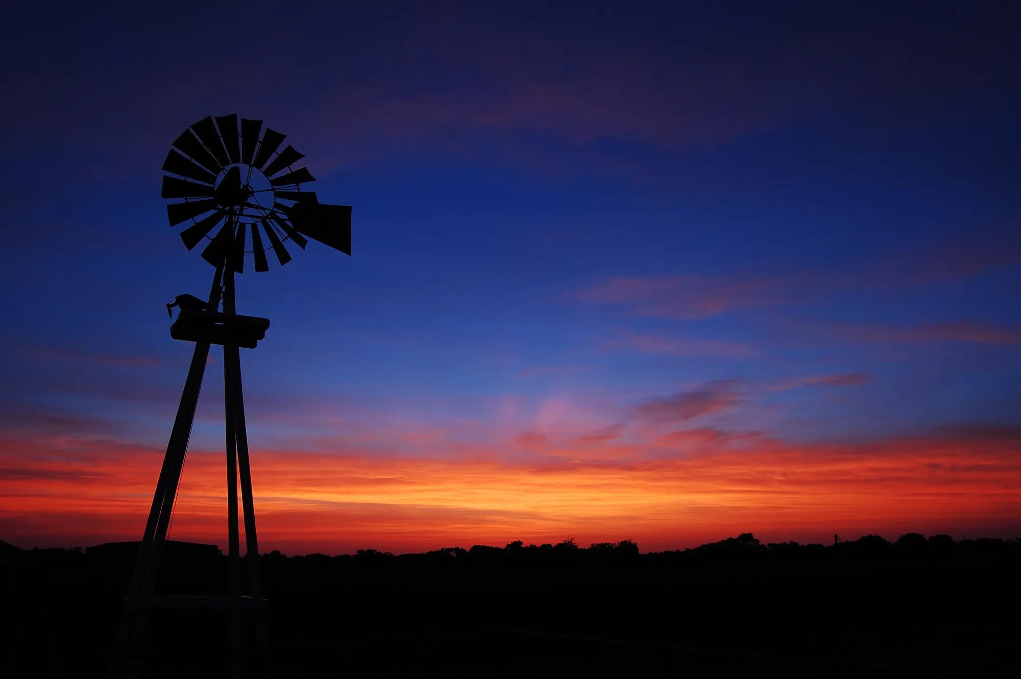 Windmill silhouette on a farm at night