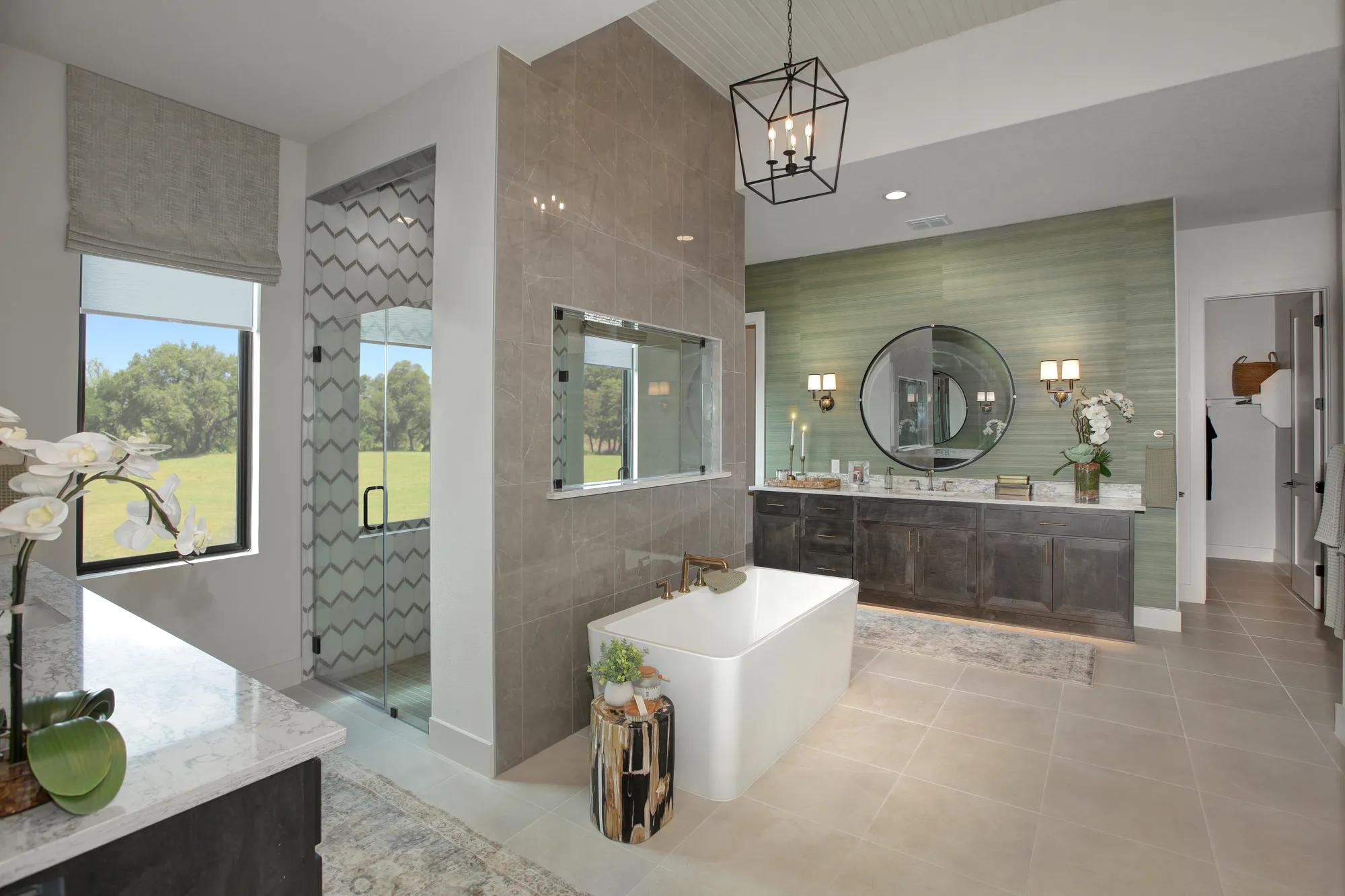 Spa-inspired primary bath with soaking tub, tile walls, and natural light in a Drees custom home