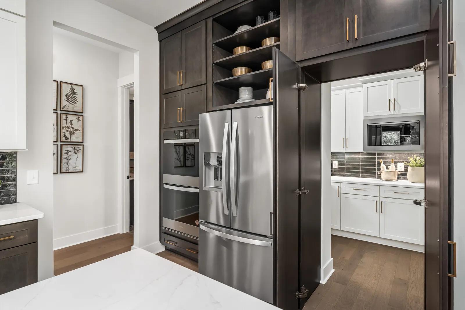 Custom home kitchen with cabinet doors to hidden working pantry