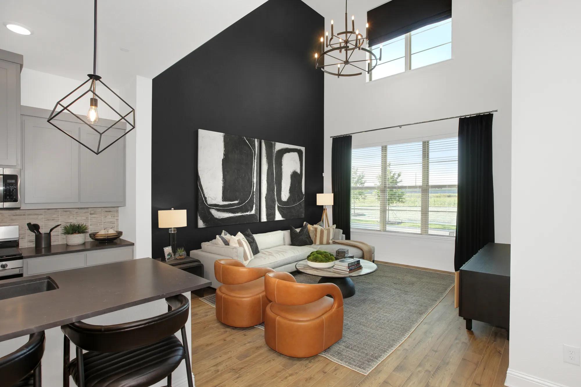 New townhome two story family room with black accent wall and chandelier 