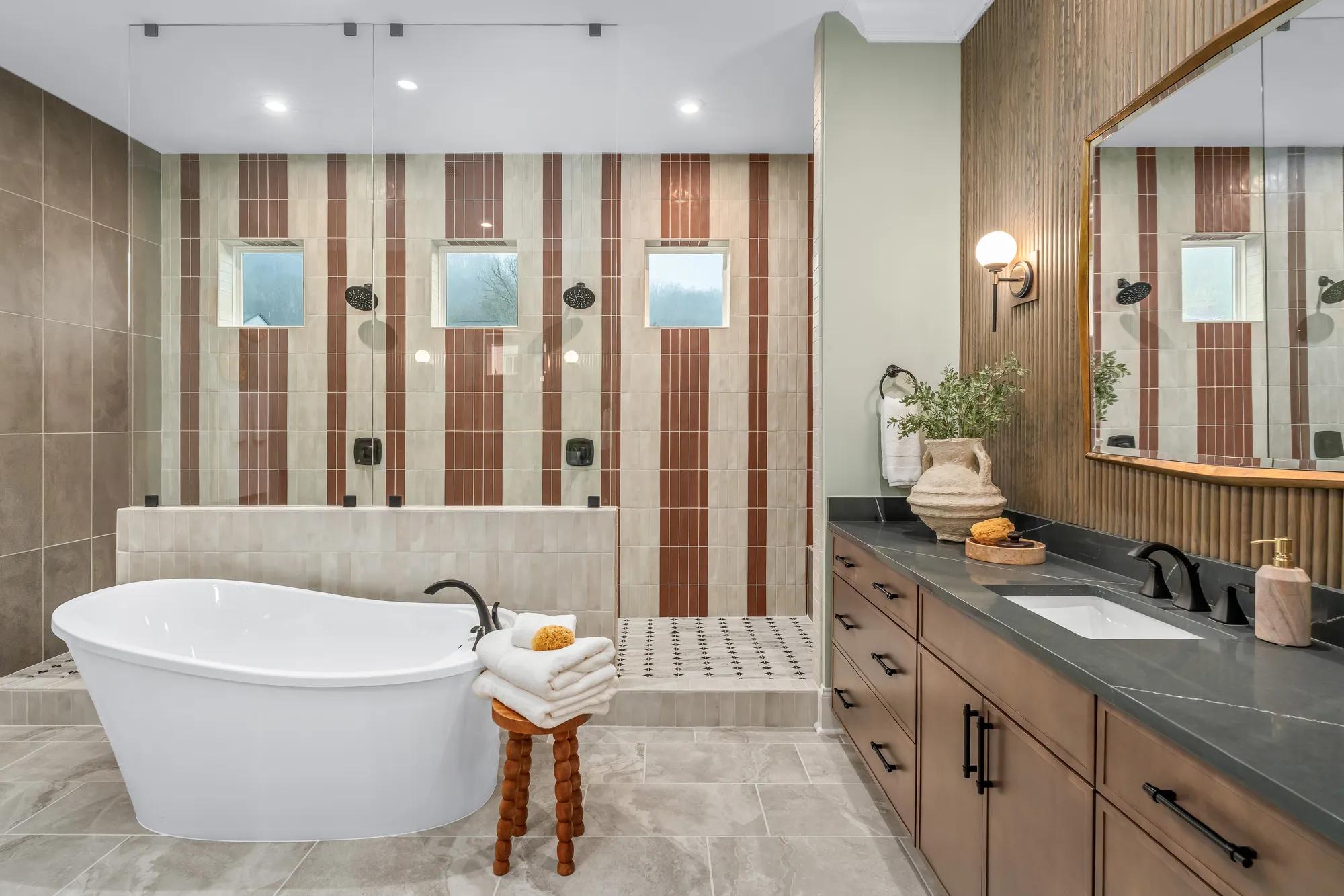 Custom home primary suite bathroom with walk through shower and freestanding tub