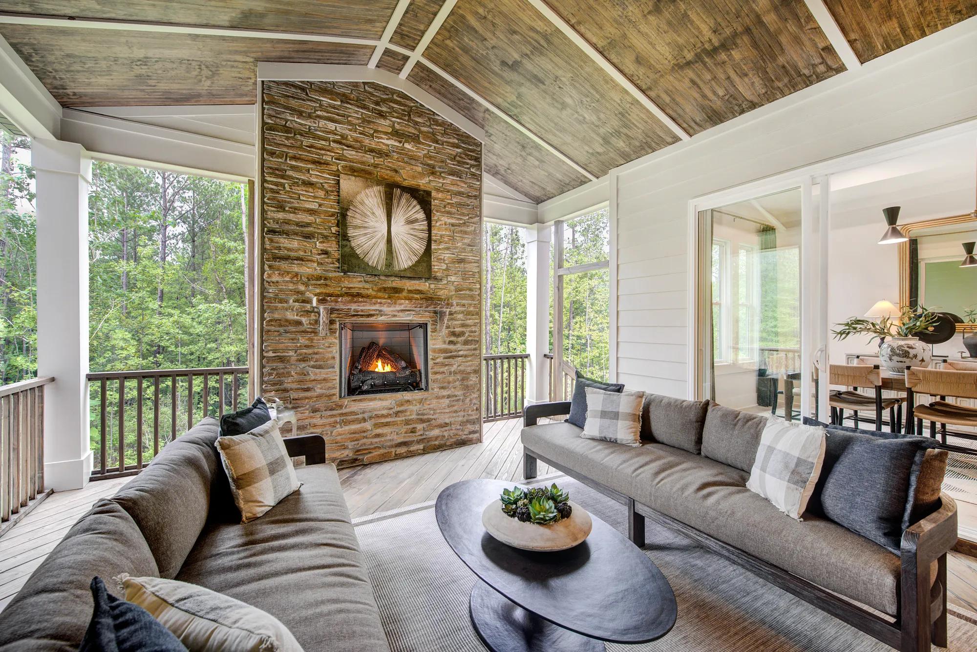 Custom home screened in porch with stone fireplace and wood panel ceiling