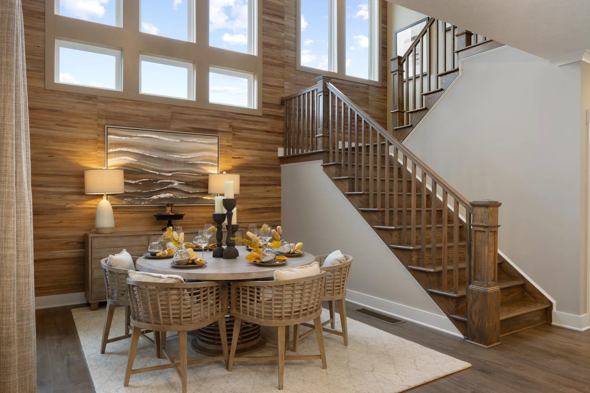two-story dining room with wood accent wall