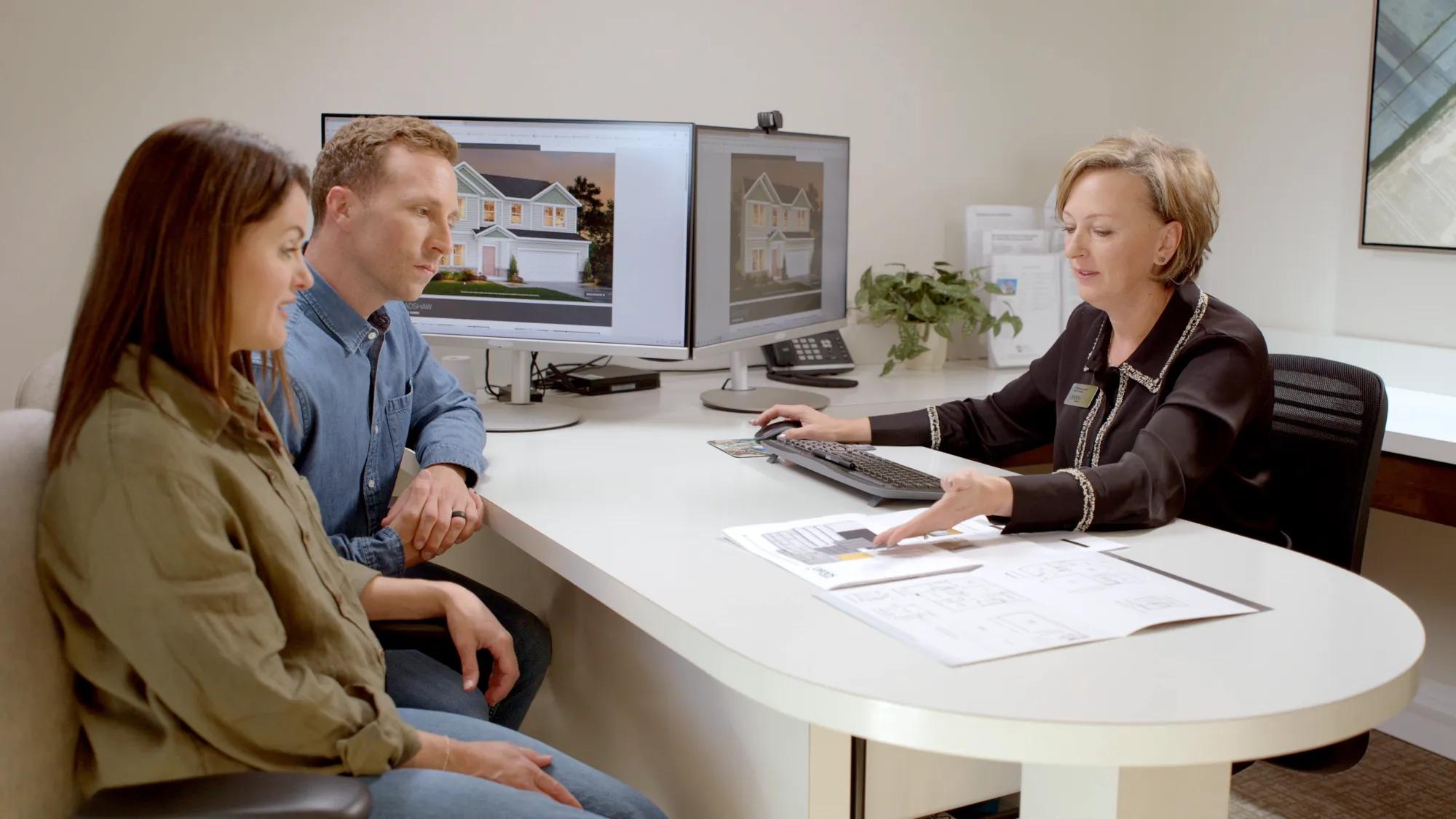 Couple finalizing custom home selections with design consultant at Drees