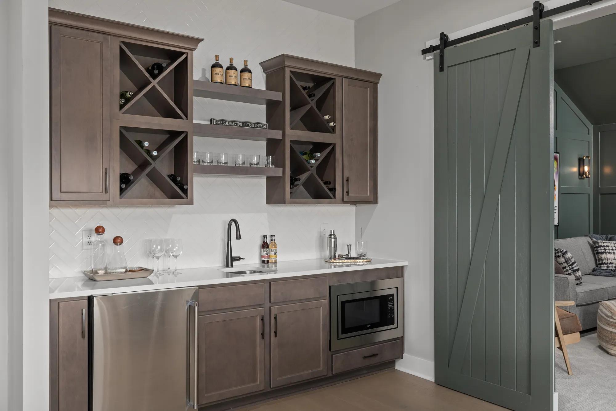 Wet bar with dark wood cabinets, mini fridge and microwave