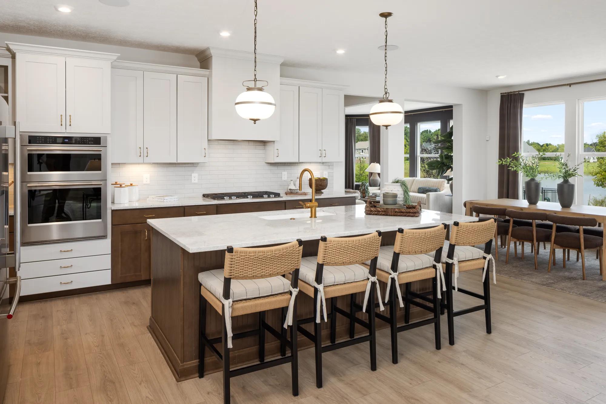 Custom home open floor plan kitchen with island overlooking a casual dining room and sunroom