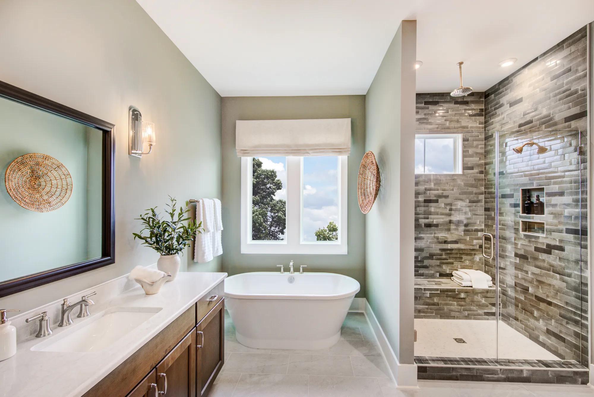 New home primary bathroom with freestanding tub and tile shower with rain showerhead and seat