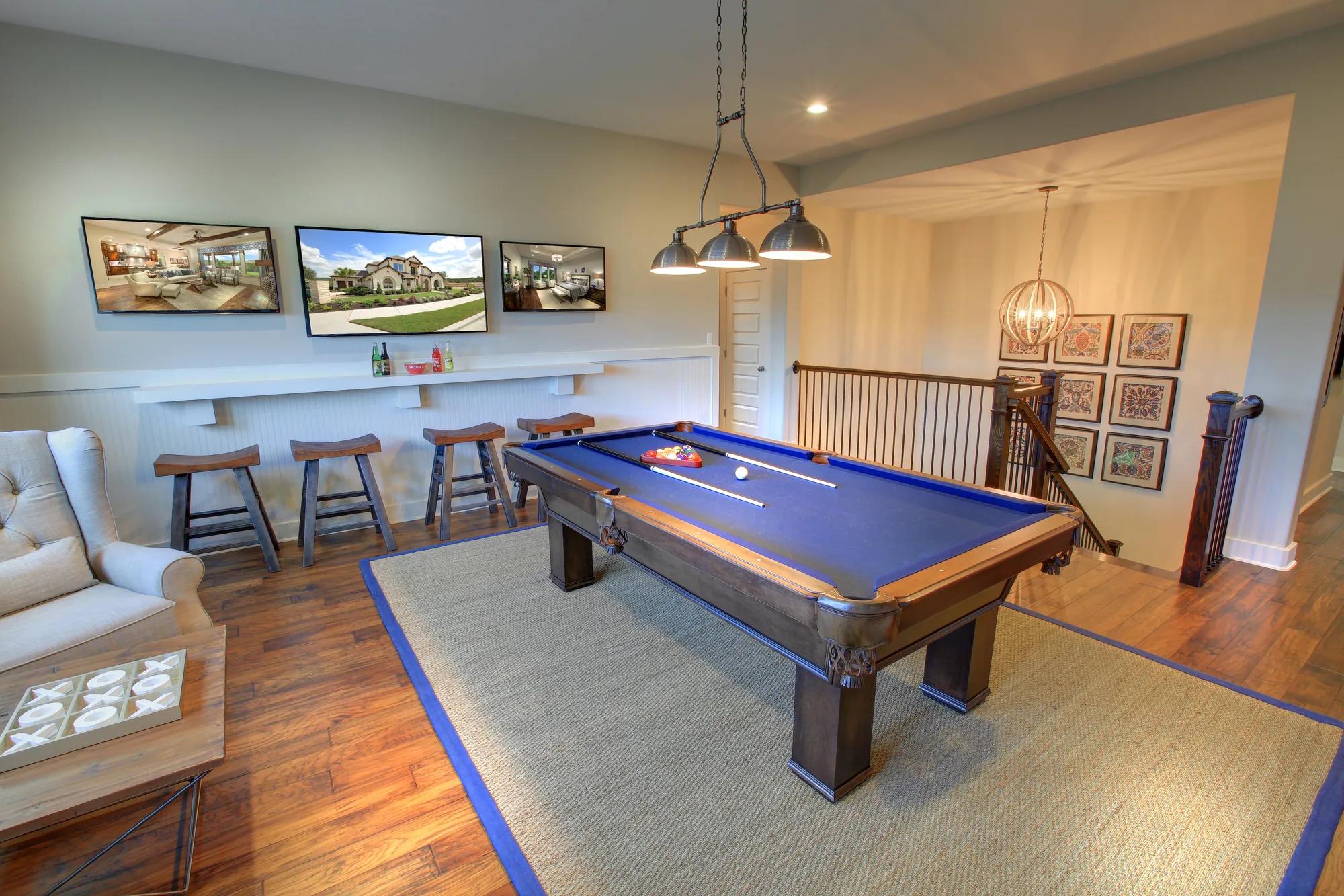 Second-story gameroom with a pool table and bar seating