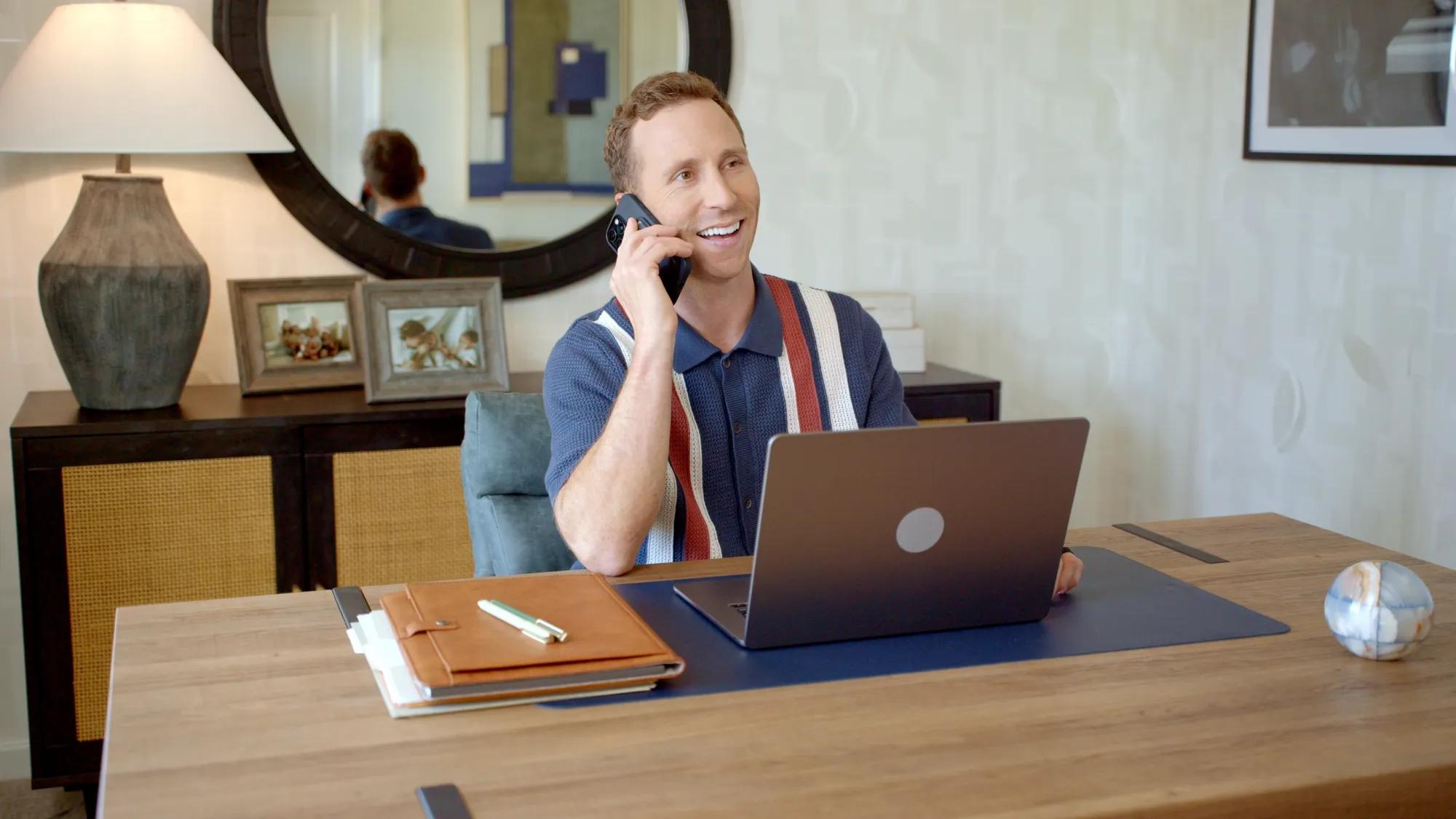 Man on phone and laptop in home office