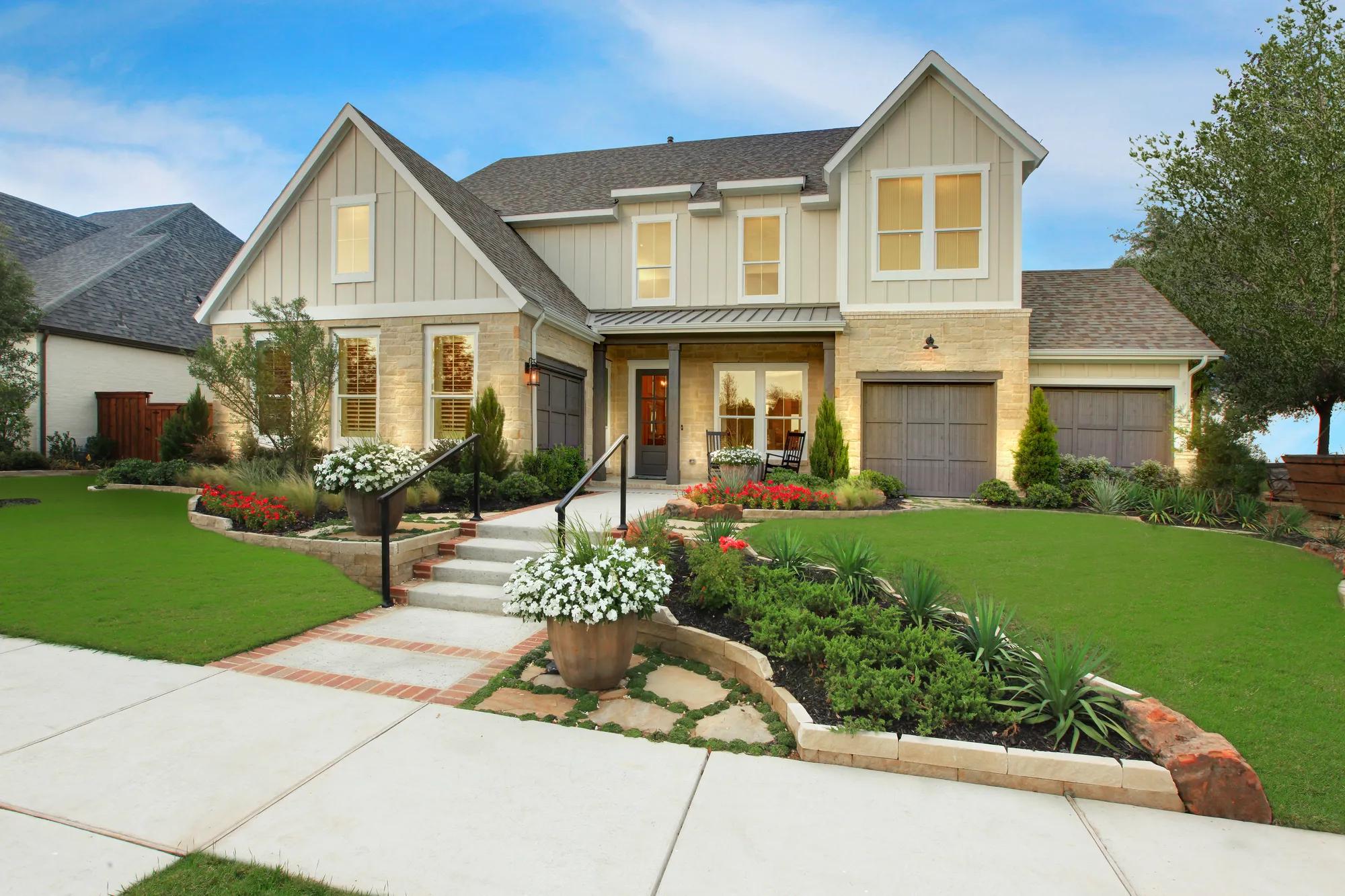vertical siding and brick two story home with side entry garage and covered porch
