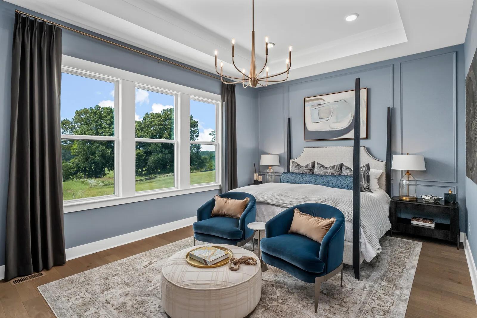 New home primary suite bedroom with light blue wainscoting accent wall and hardwood floors