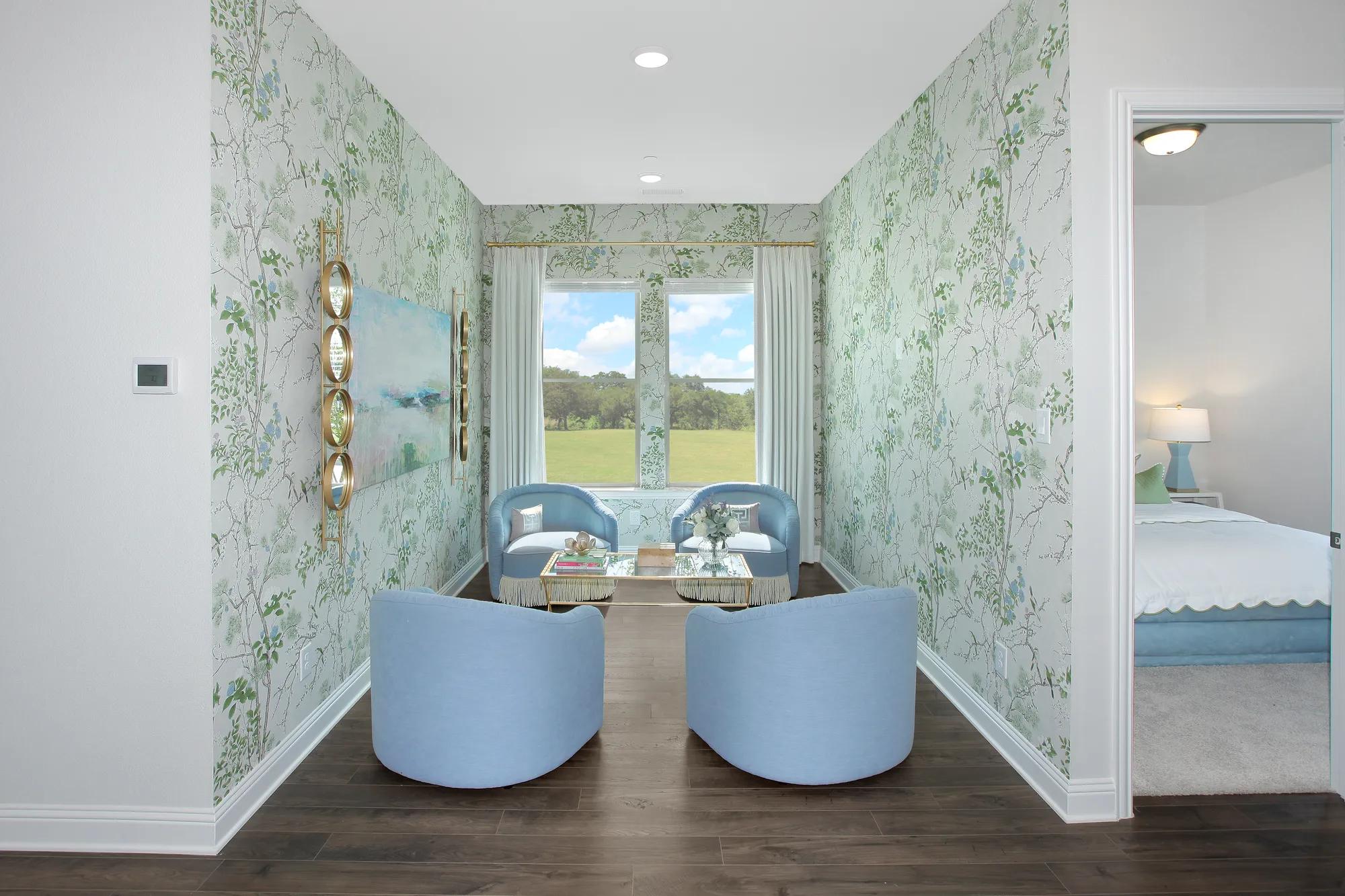 Custom townhome flex space with green wallpaper and blue chair sitting area