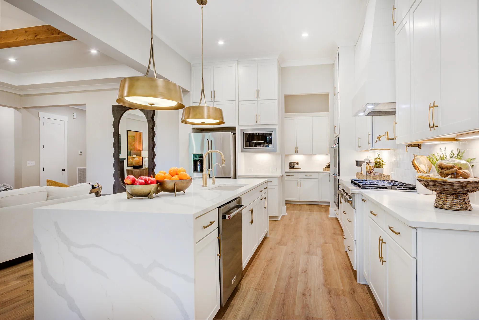 New home kitchen marbled white waterfall island with gold finishes