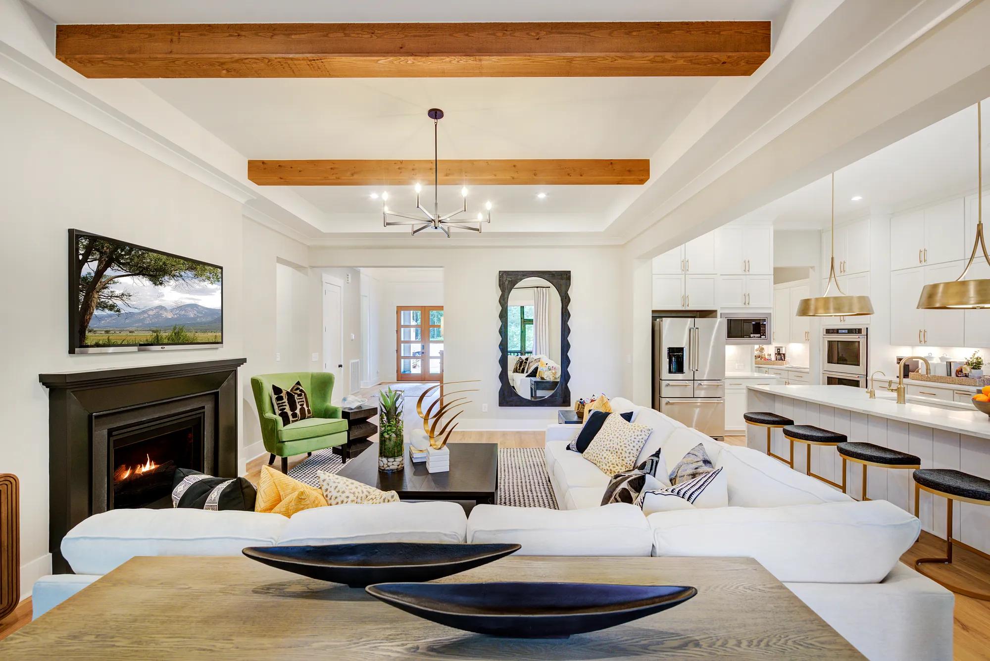 Custom home family room with black fireplace and wood beam ceiling