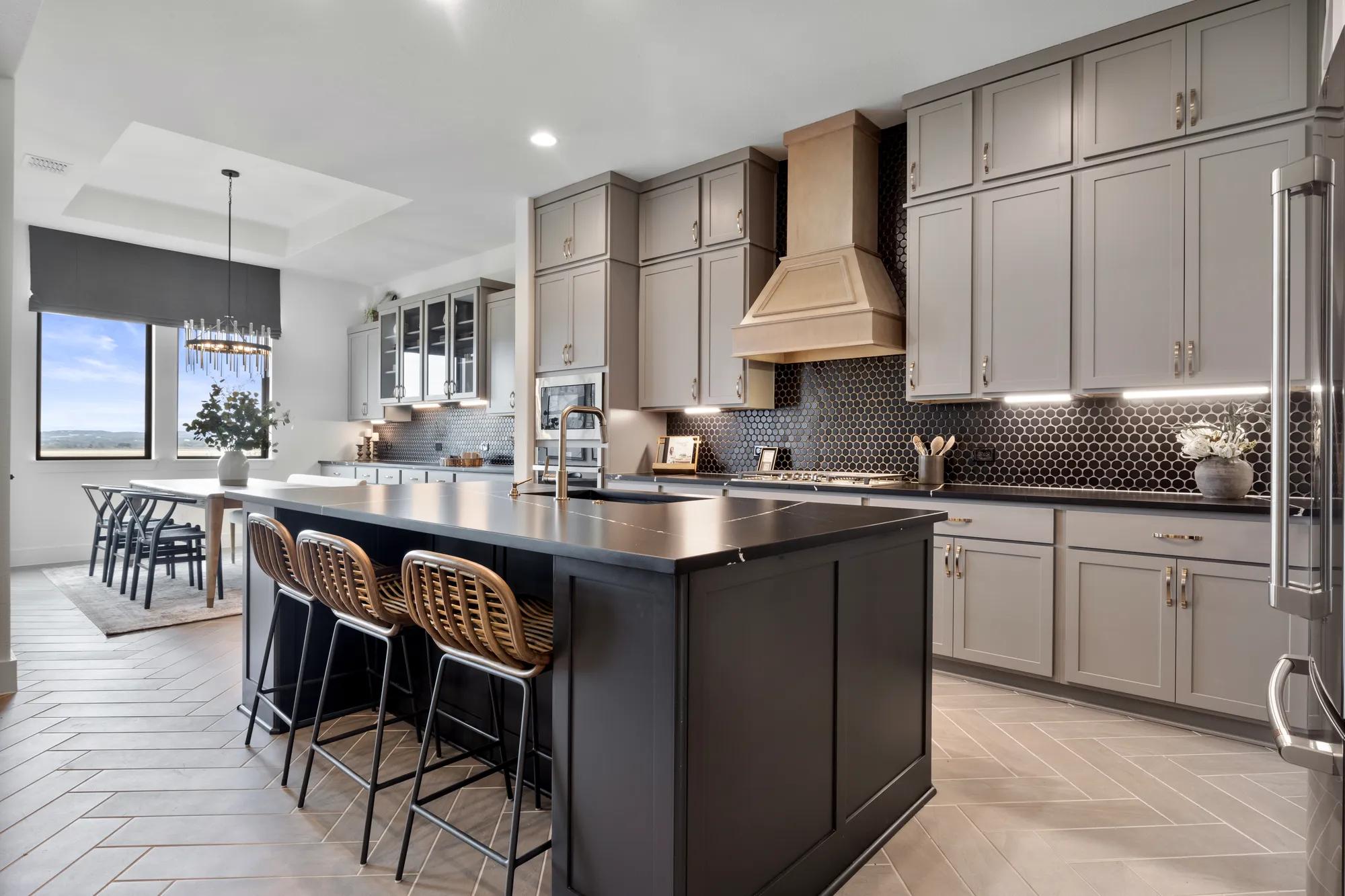 Custom home kitchen with black countertops and black backsplash tile