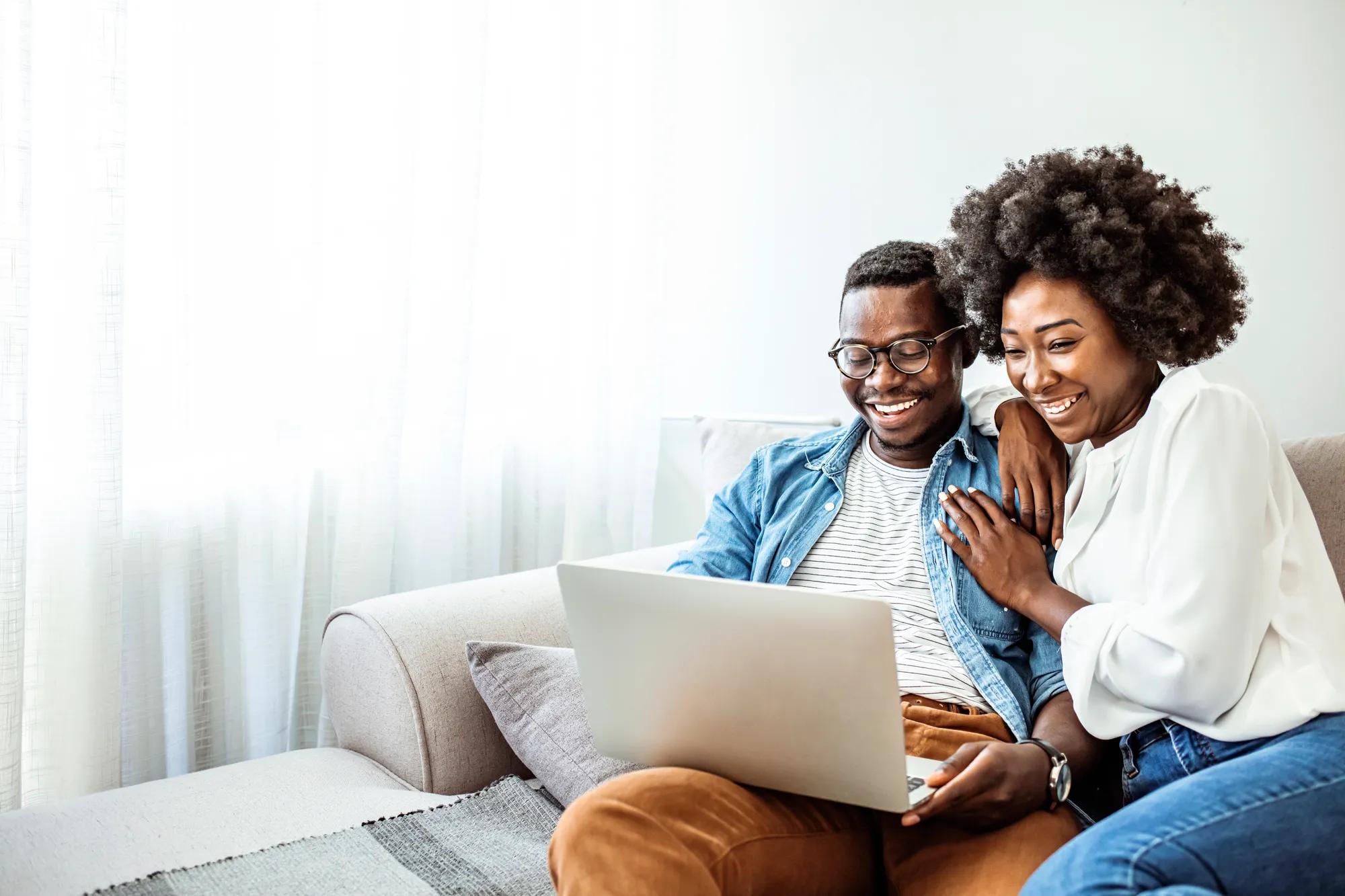 Couple using laptop in new home family room