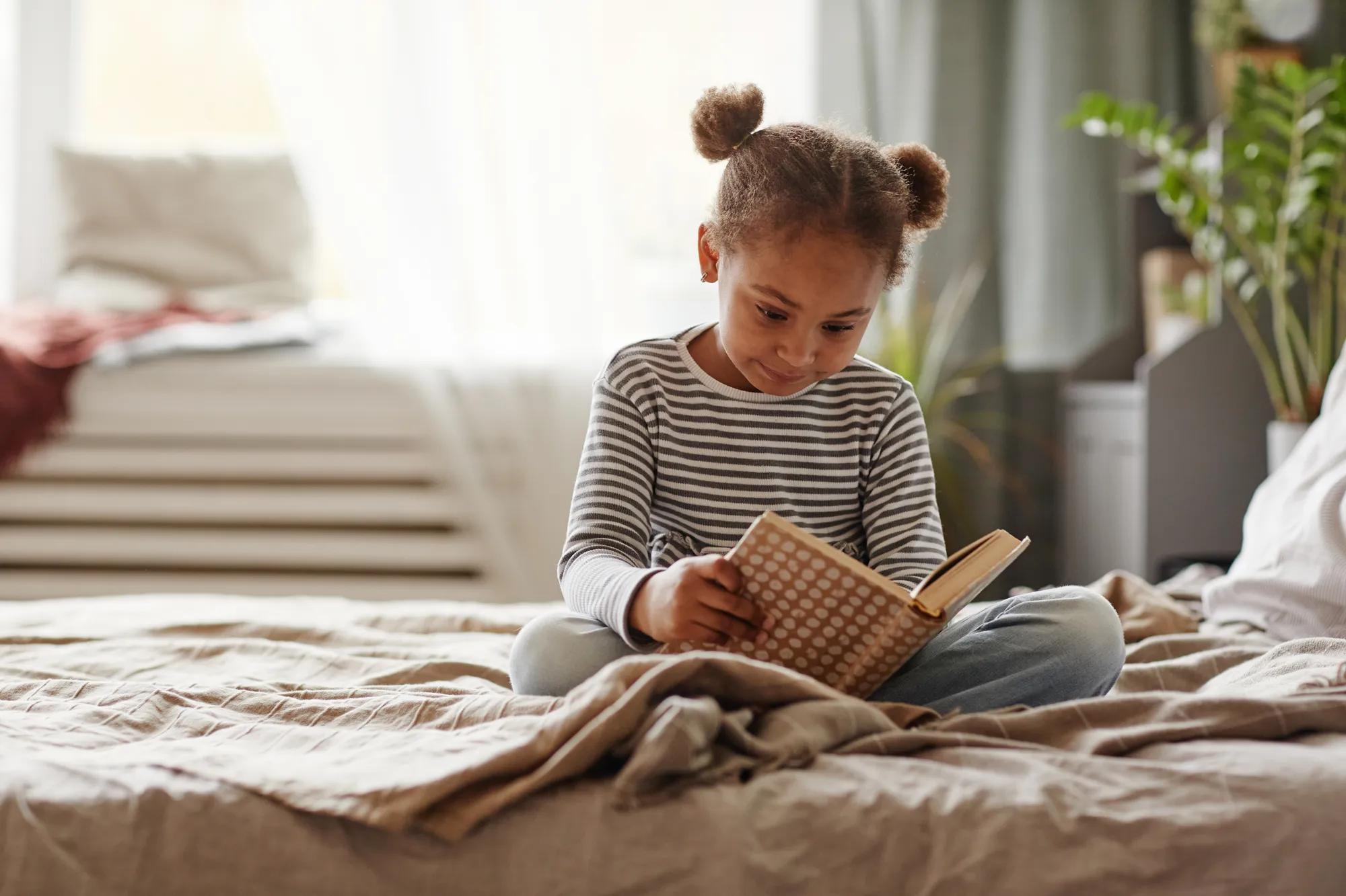 Children reading a book in bedroom