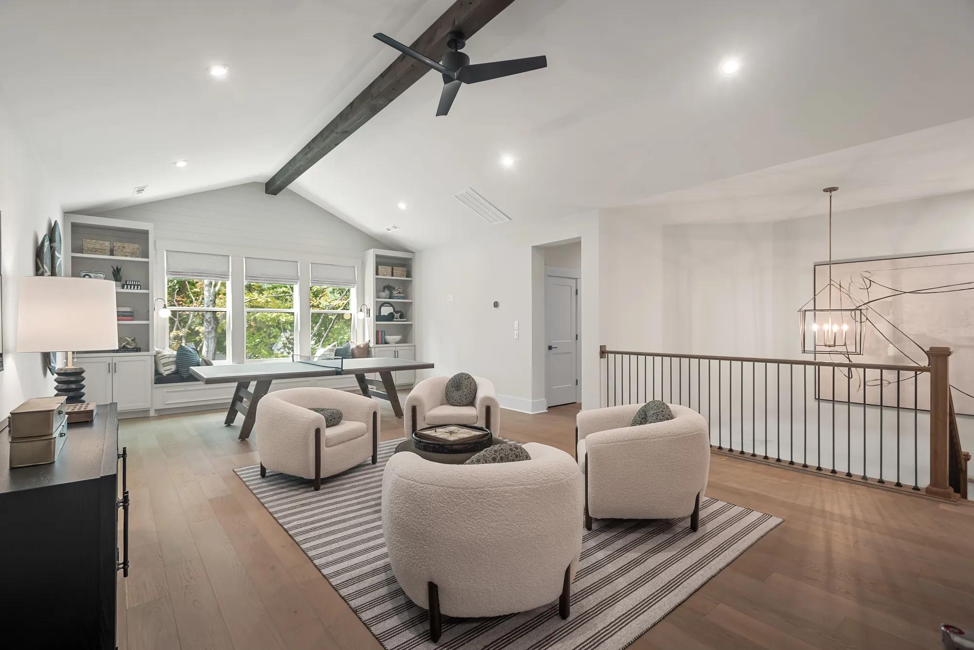 New home upstairs gameroom with hardwood floor, beam ceiling, and built in bench