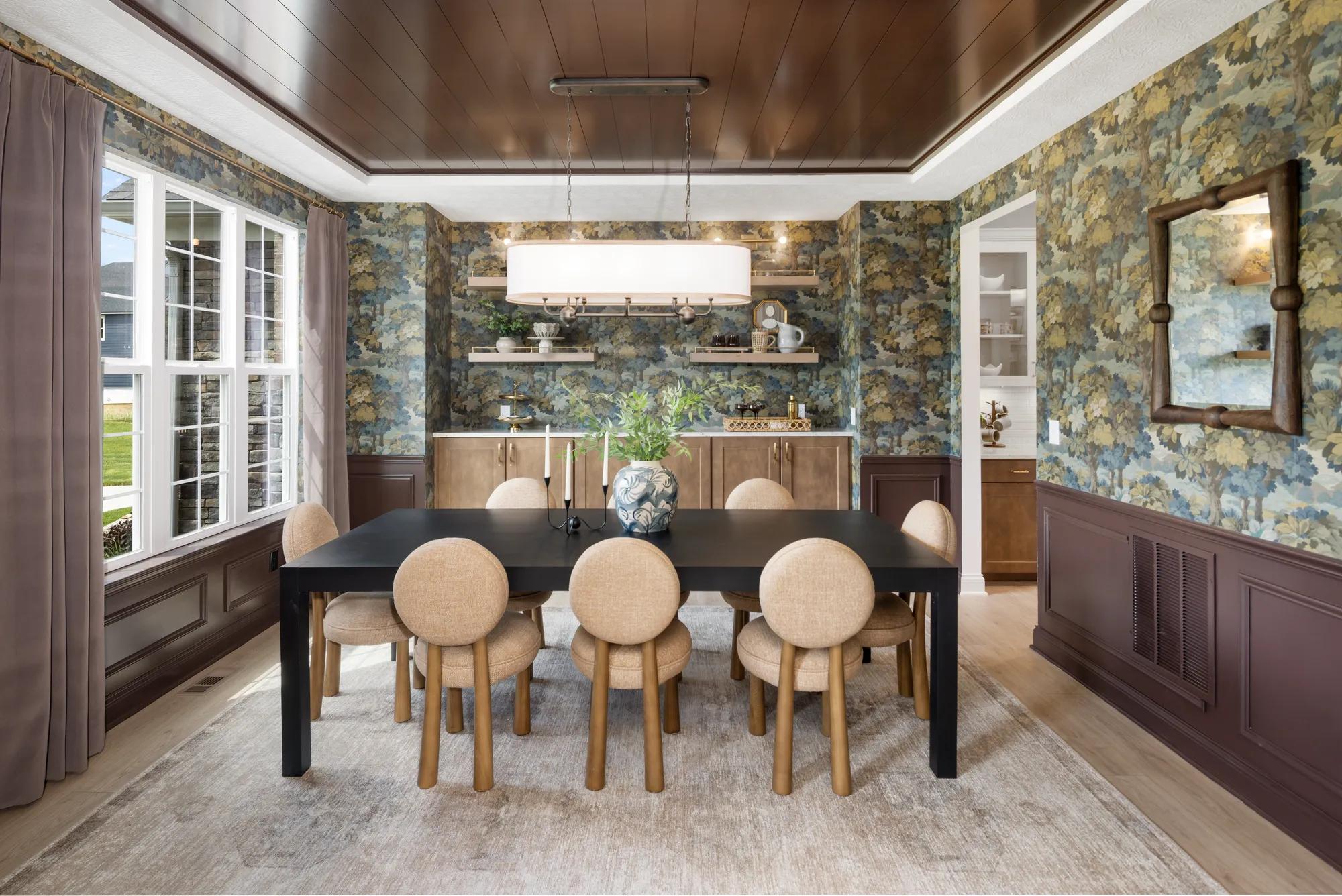 Custom home formal dining room with dark half-wall wainscoting, wallpaper, painted panel ceiling, and built-in buffet