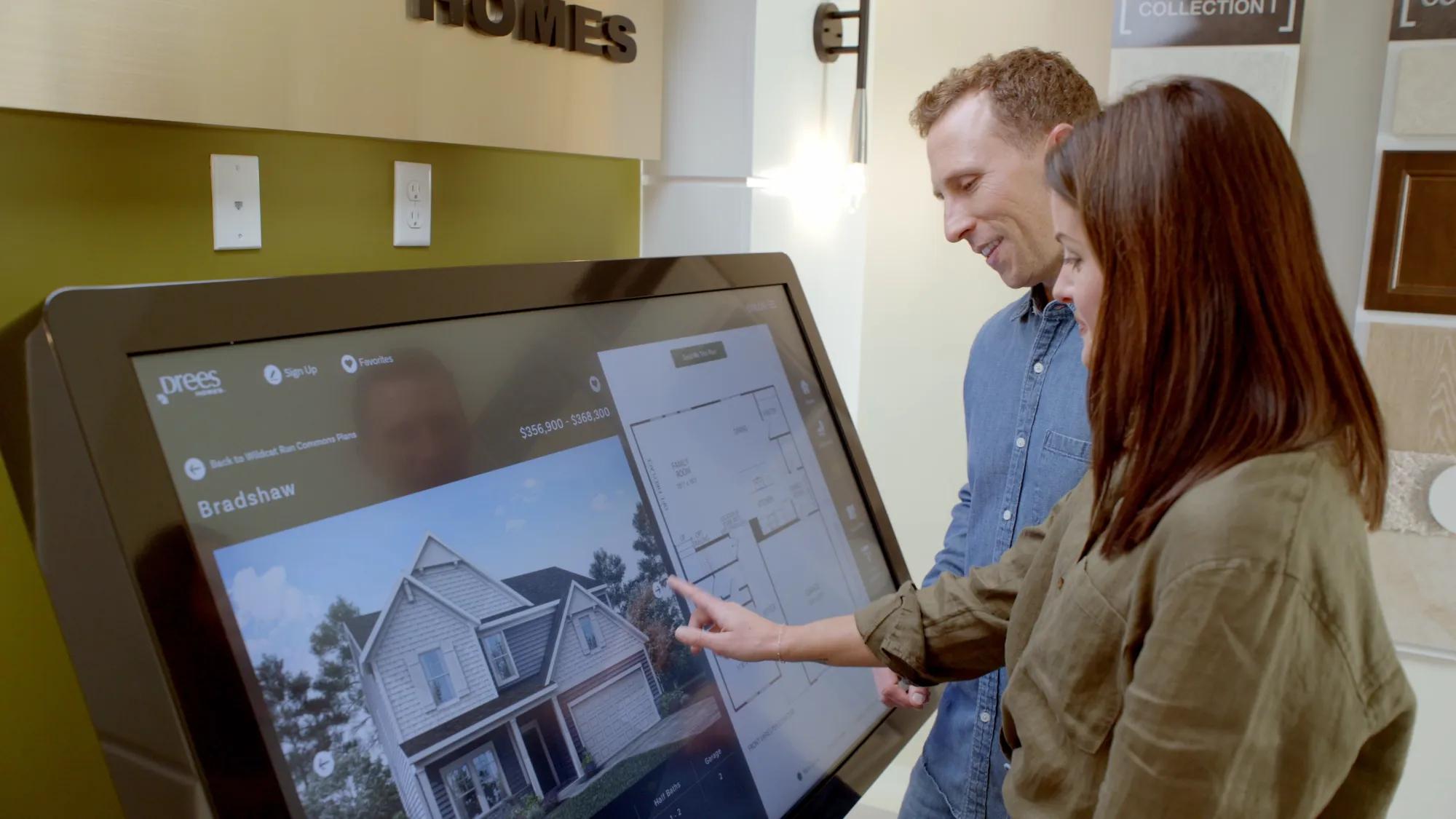 Couple using kiosk at Drees model home