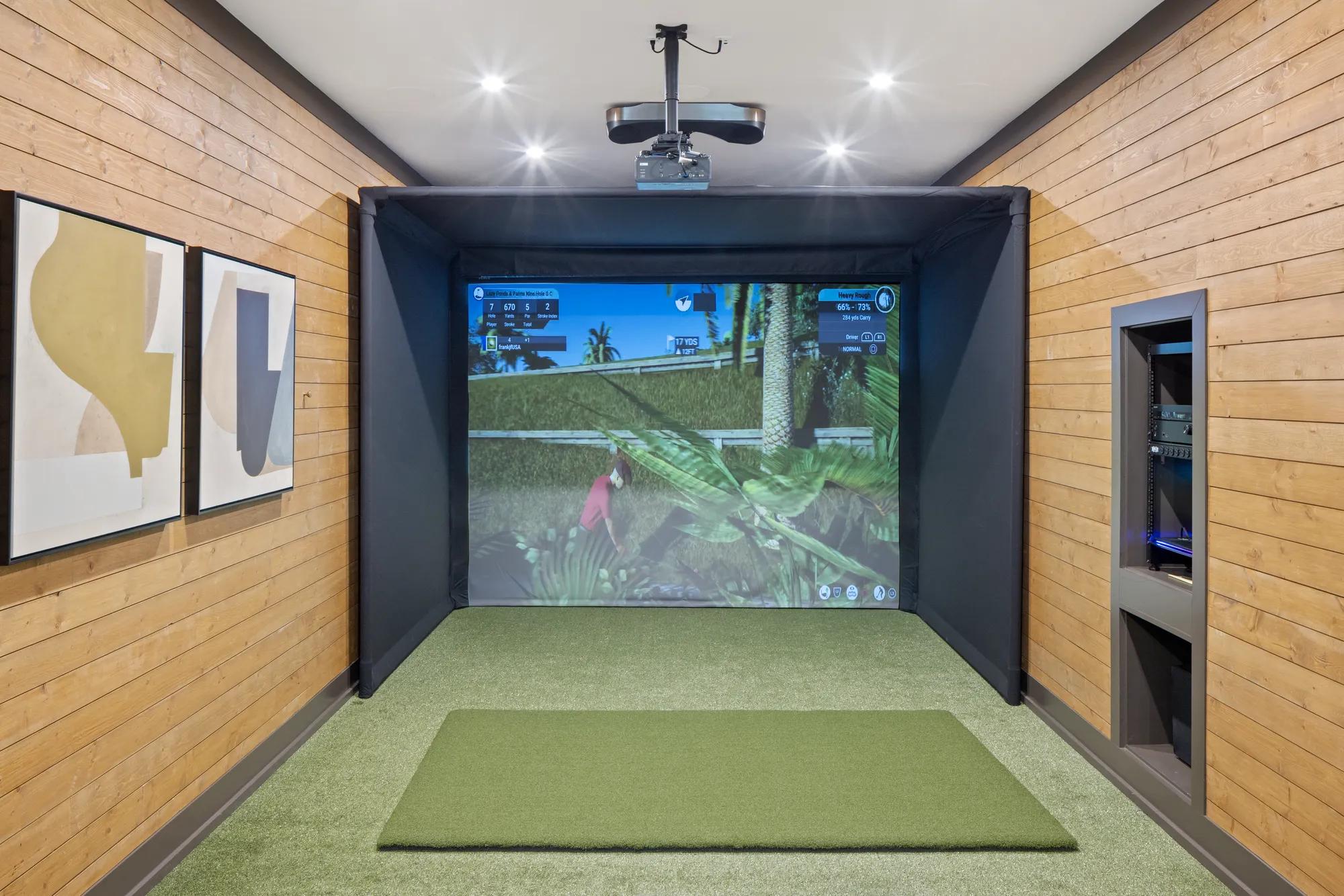 Custom home gameroom golf simulator with green carpet and wood panel walls