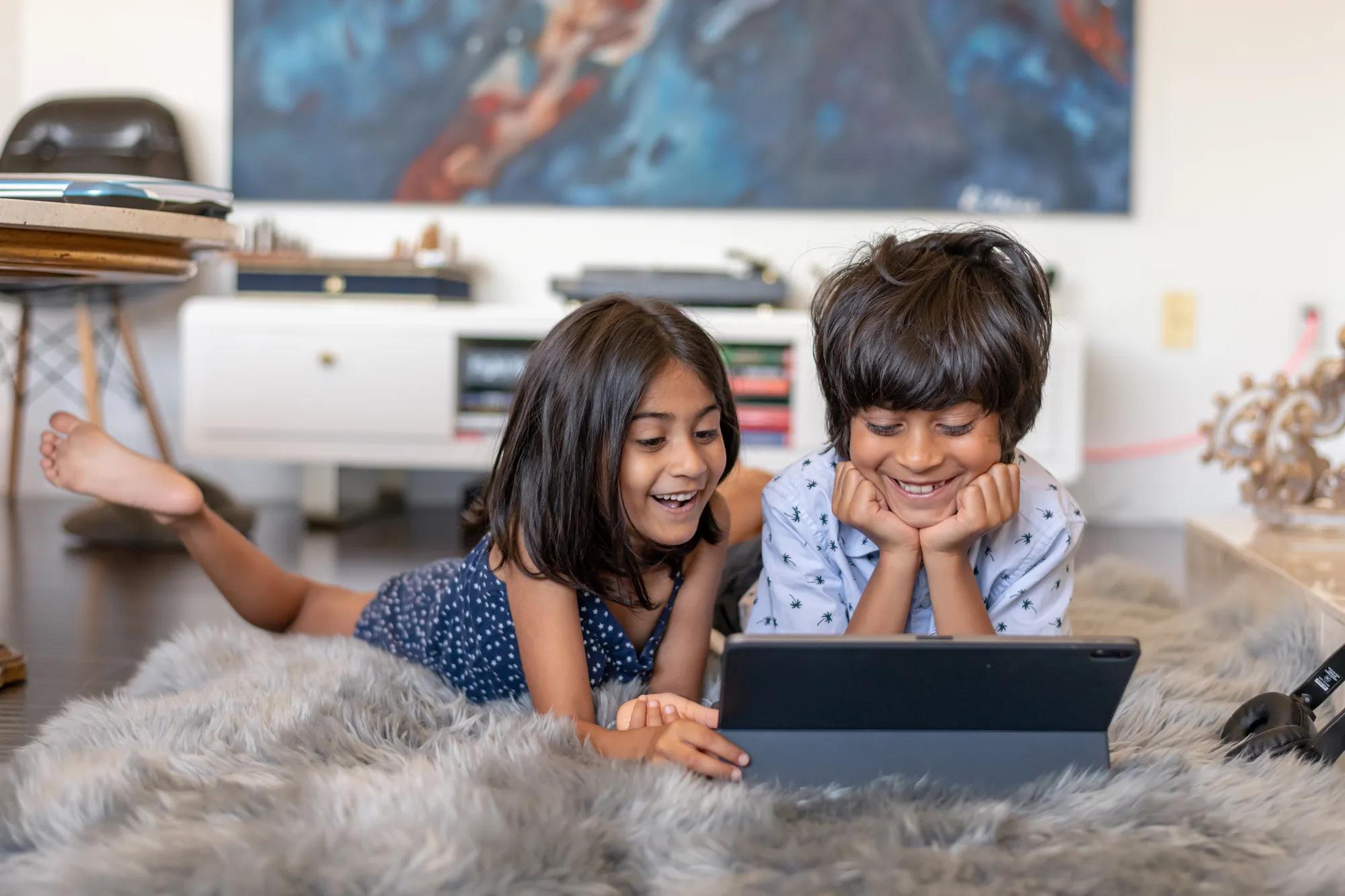 Children enjoying tablet in new home