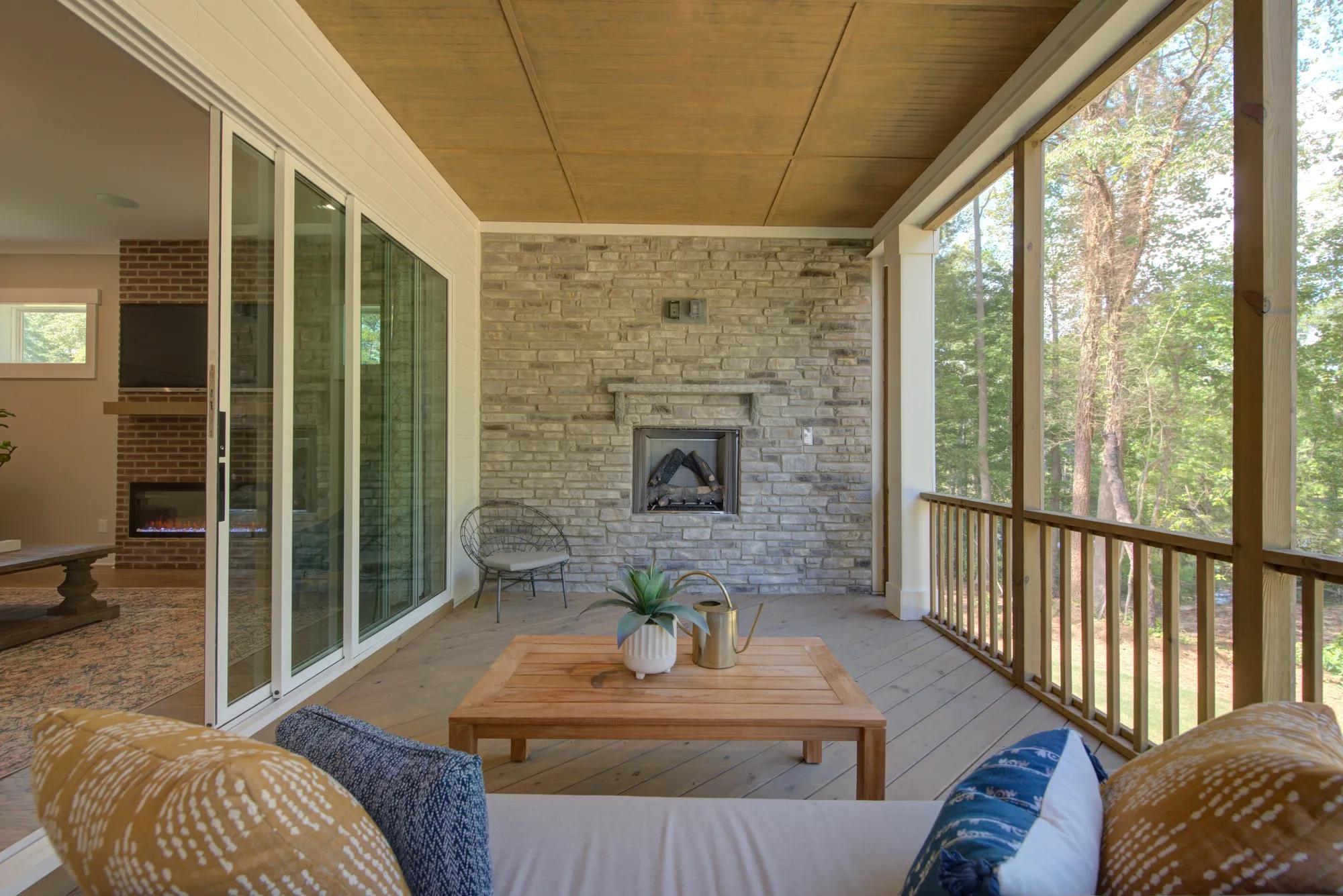 covered deck with stone fireplace and seating area