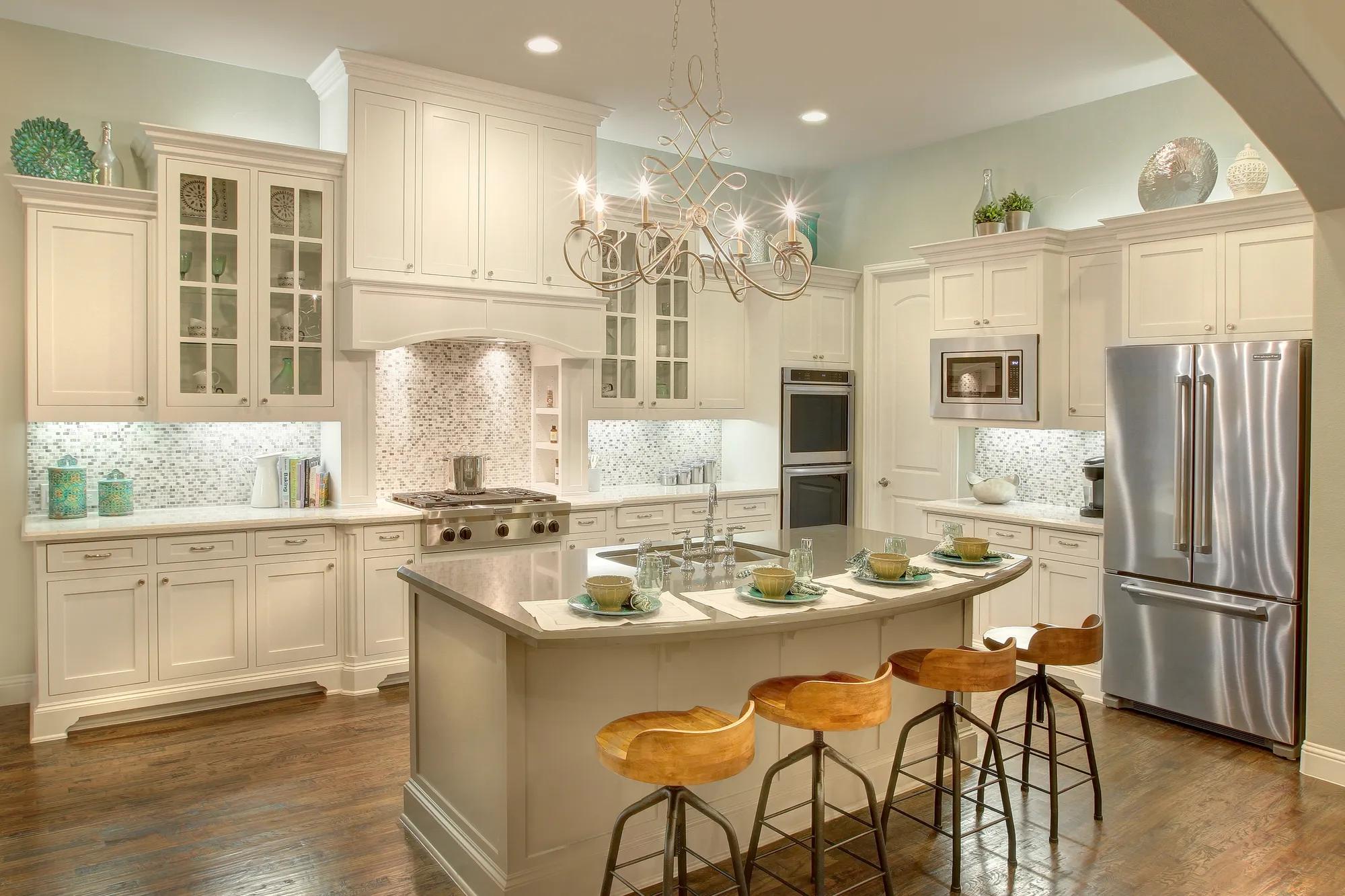 Kitchen with white cabinets, chandelier, island, hardwood floor