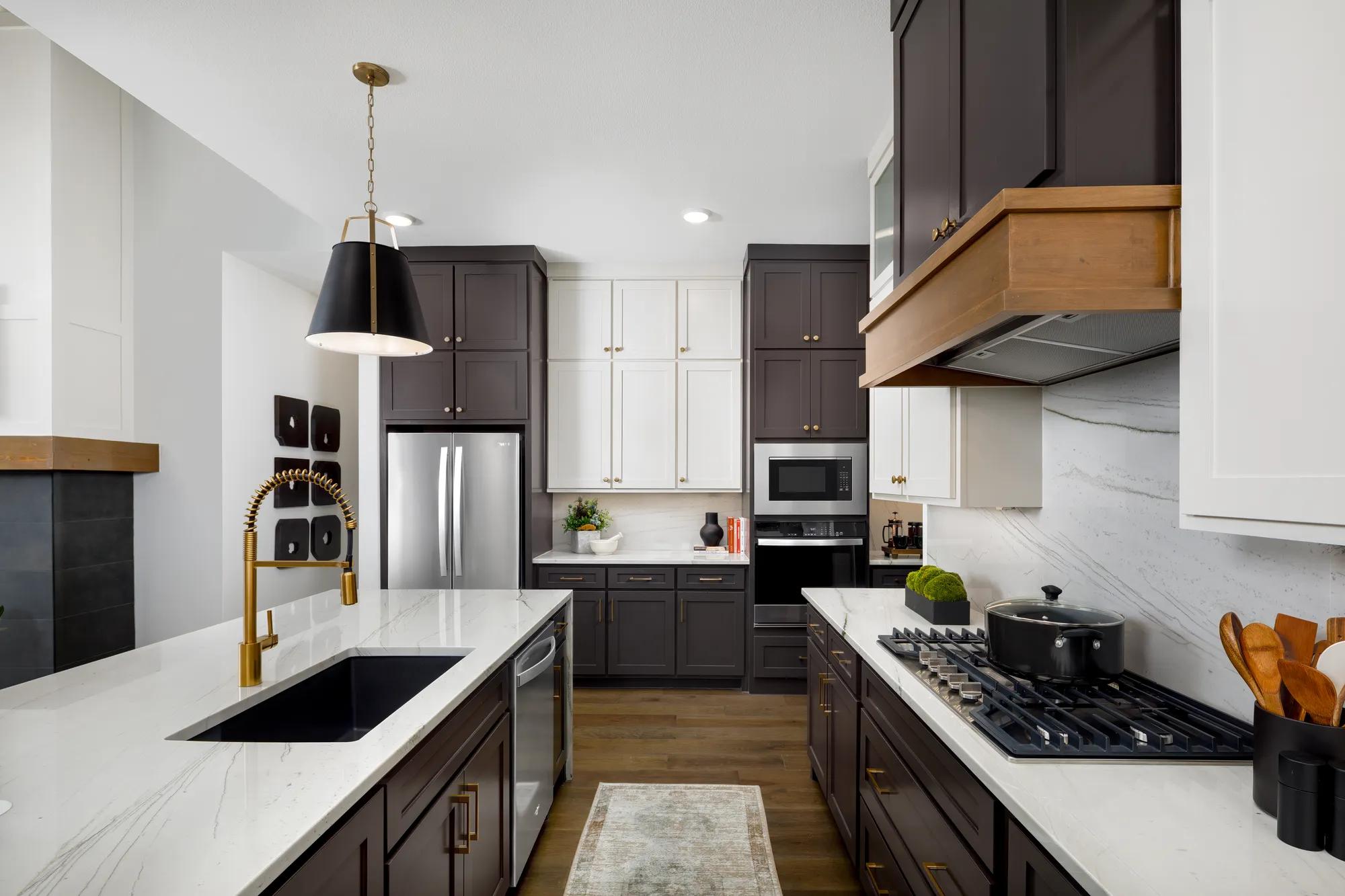 Custom home kitchen with two-tone cabinets and marbled countertops extending to the backsplash 