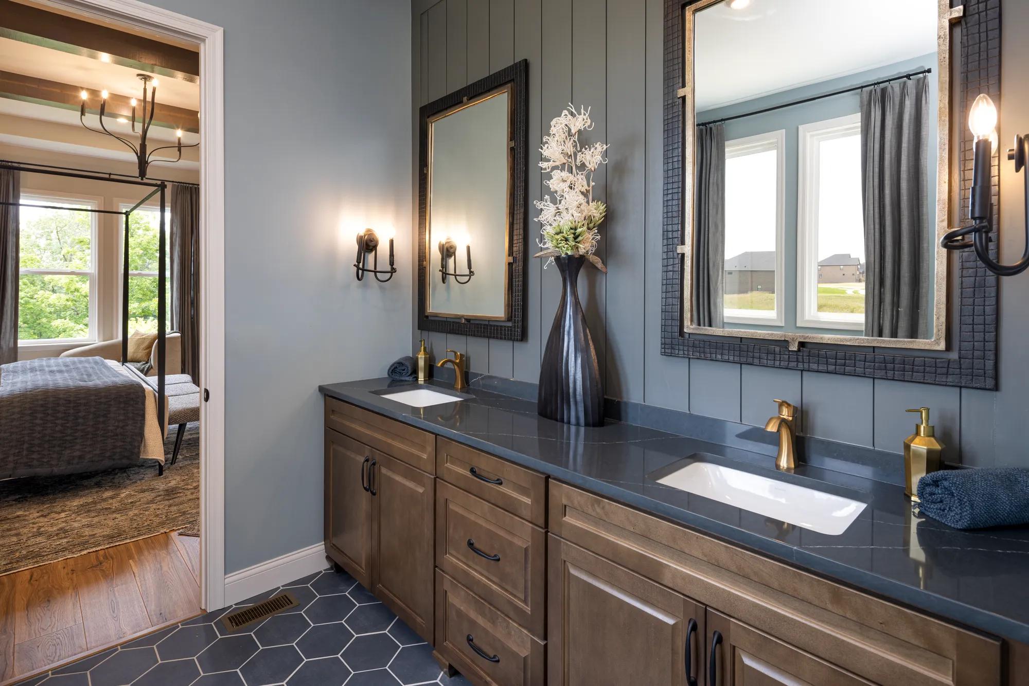 Custom home moody primary bathroom with dark wood cabinet vanity and charcoal paneling and tile